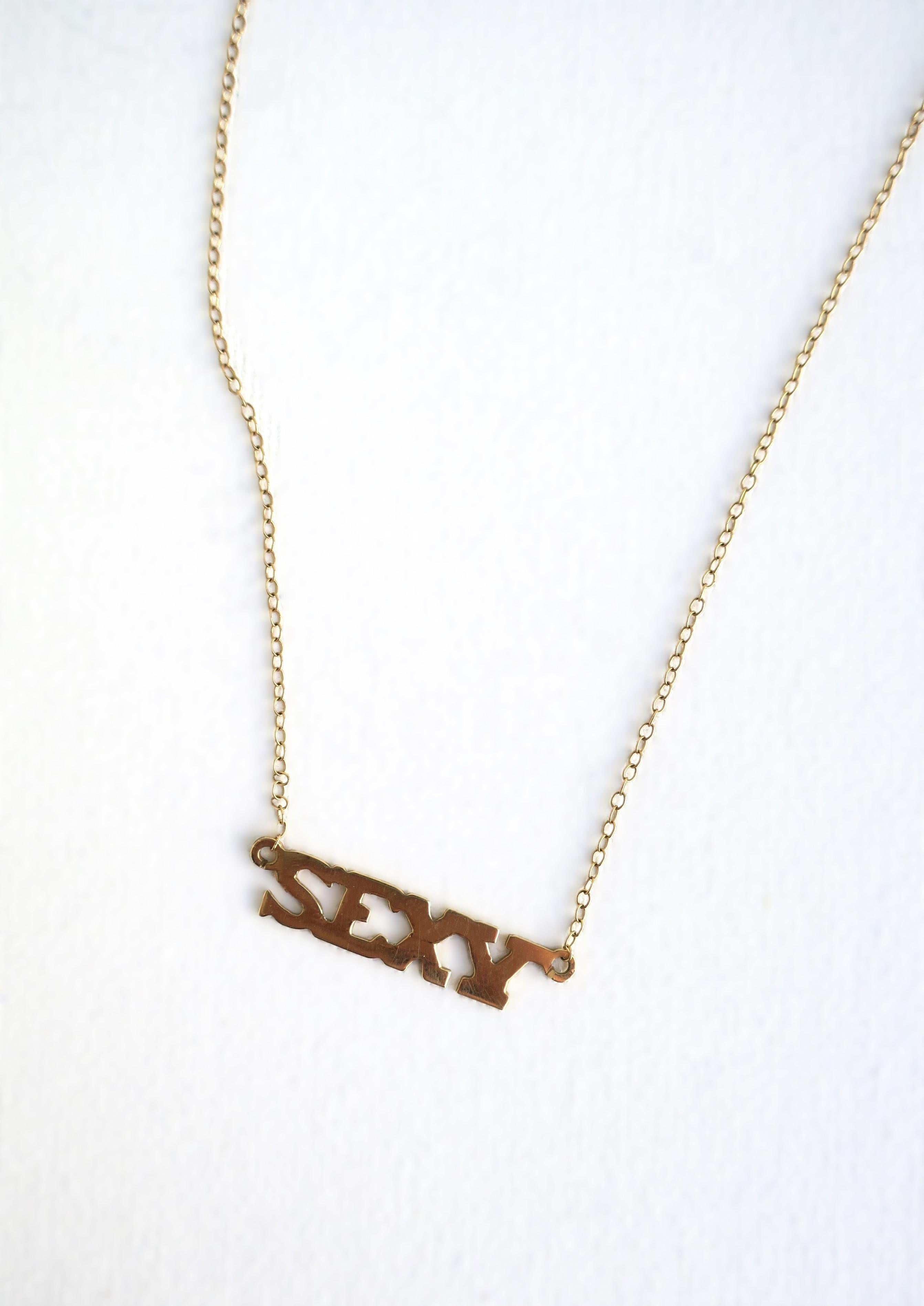 A chic and fun '70s Modern 'SEXY' nameplate necklace in 14-karat yellow gold, circa 1970s, Disco era. Wear alone or stack with other necklaces. Necklace bears both marker's mark and 14-karat gold mark, as shown in the last two images. Dimensions: