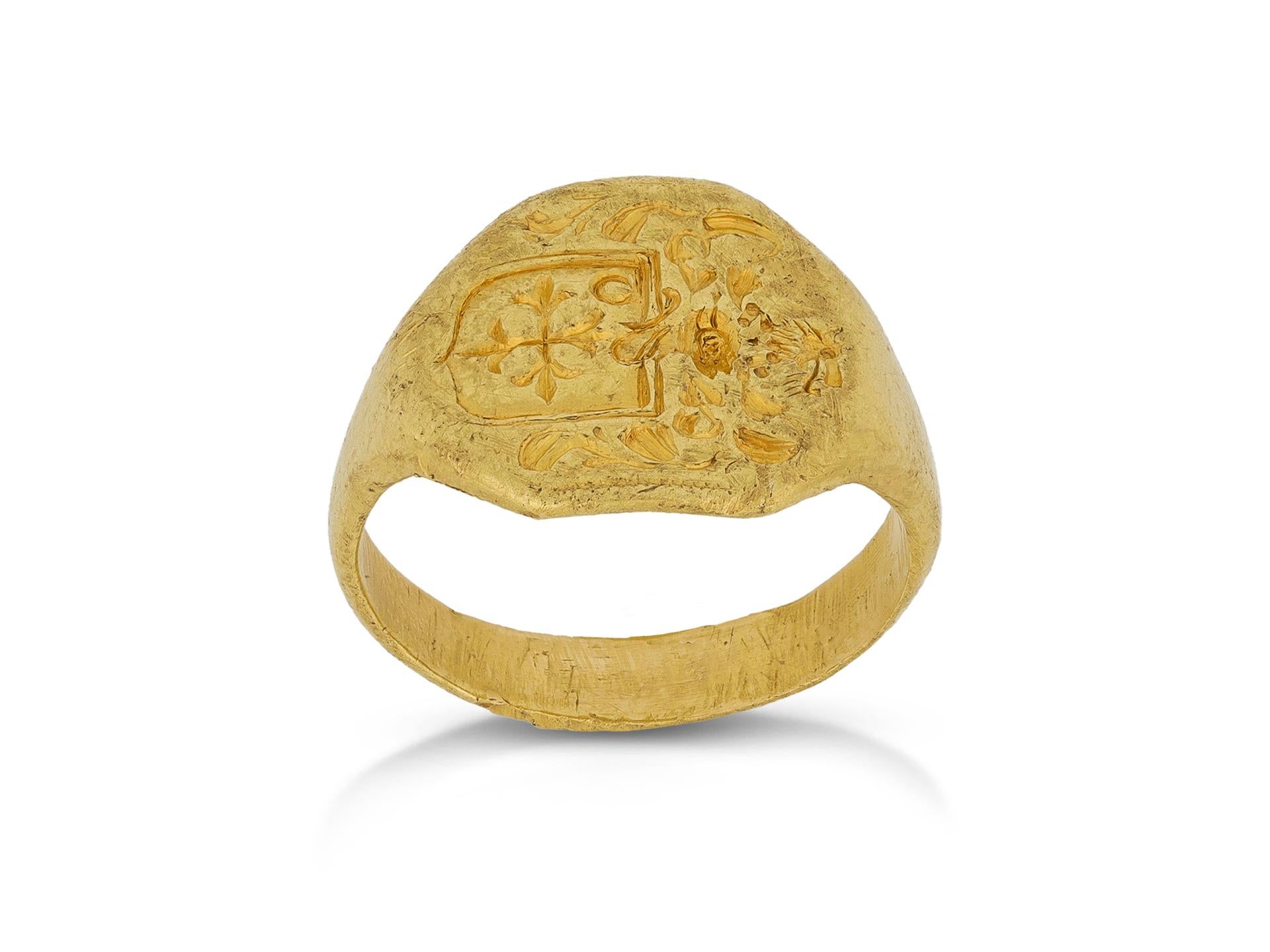Gold signet ring attributed to the Ward family. A yellow gold signet ring, the central octagonal plaque featuring an engraved crest and coat of arms showcasing a wolf's head atop a cross flory, which has been attributed to the Ward family, tapering