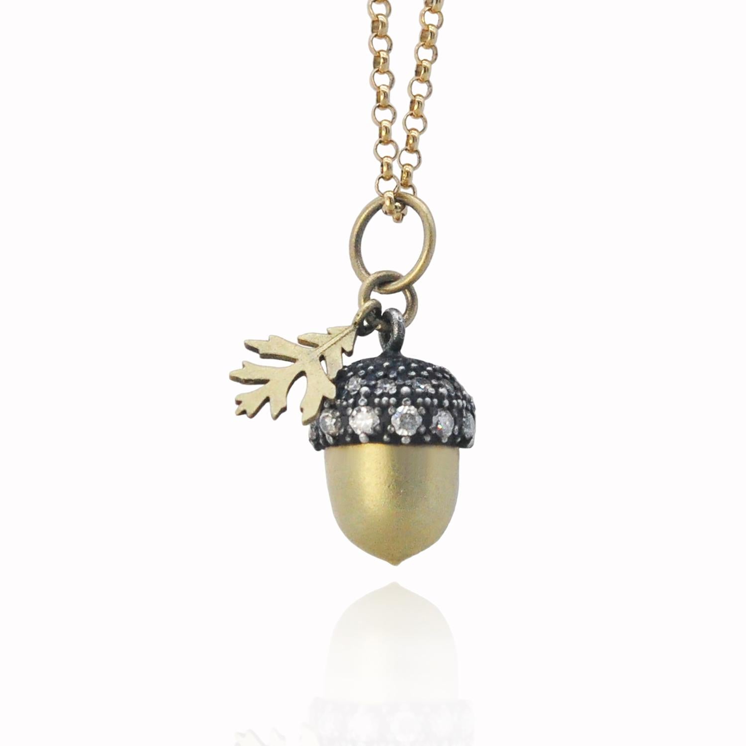 A beautifully crafted oxidized silver and 18k yellow gold acorn set with diamonds with an 18k yellow old gold oak leaf charm that hangs delicately from a 14k yellow gold chain. The perfect piece for the sophisticated bohemian on your gift