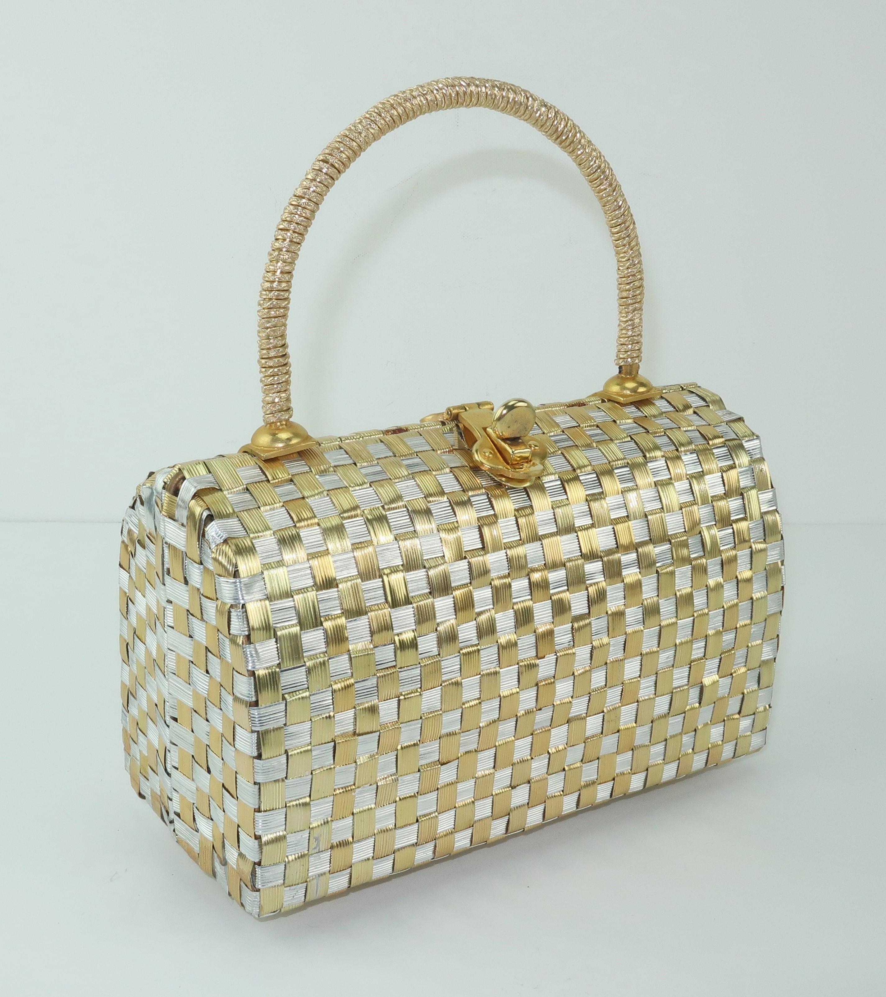 A little treasure chest of a handbag!  This sweet basket weave style handbag covers all the metallic bases with both silver and gold metal bands.  The ornate handle, turn lock closure and gold vinyl interior finish the look perfectly with just