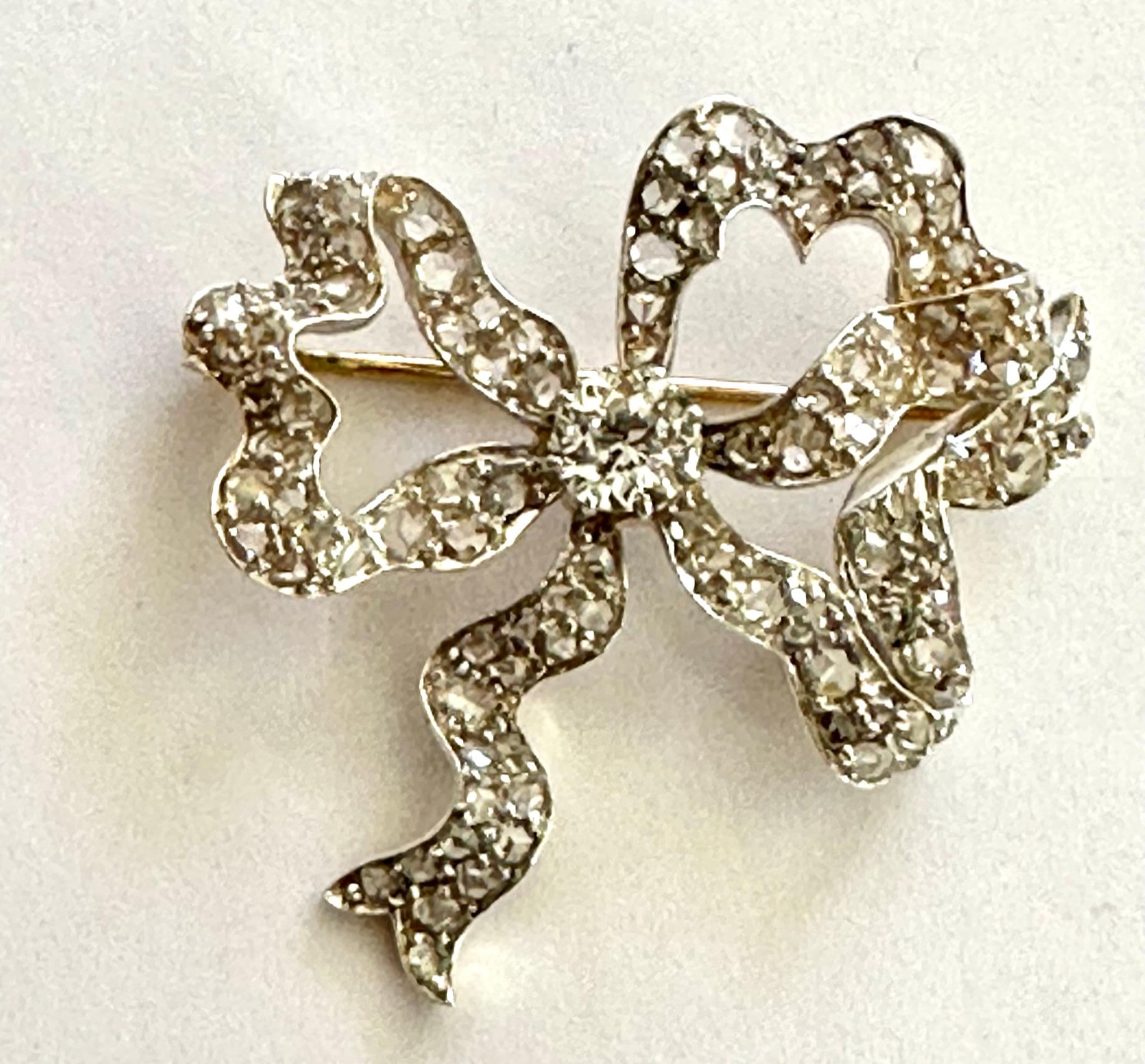 A yellow gold/silver bow brooch set with an old cut (European) diamond and 107 rose cut diamonds
1 old european cut diamond: 0.70 ct P1 J.
107 rose cut diamonds together weigh: 1.40 ct, various qualities.
This elegant brooch was made around 1900 in