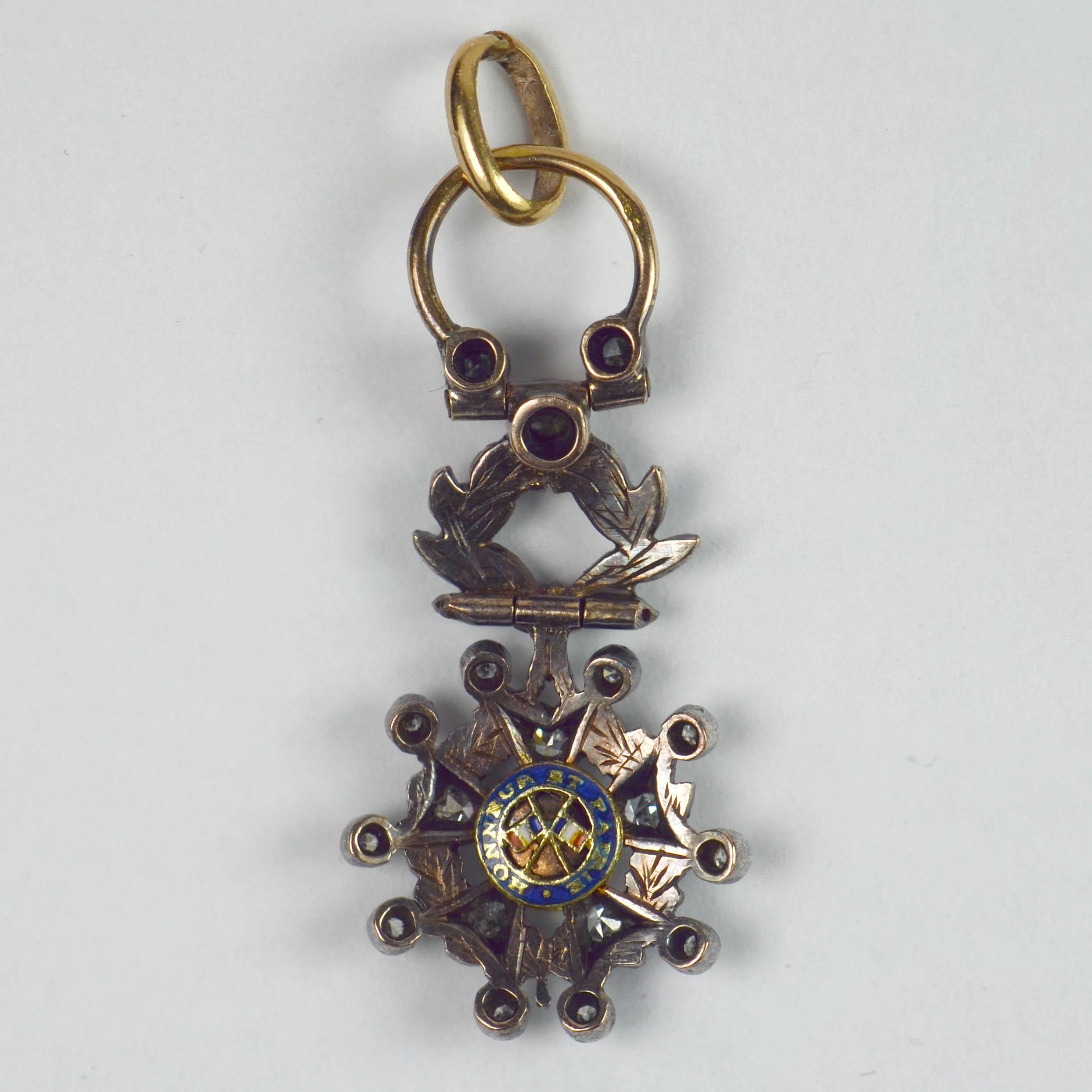 A French 18 karat (18K) yellow gold, silver and base metal charm pendant designed as a miniature Legion d'Honeur medal. Set with 18 single-cut diamonds with a total approximate weight of 0.36 carats, and highlighted with green enamel. 

Dimensions: