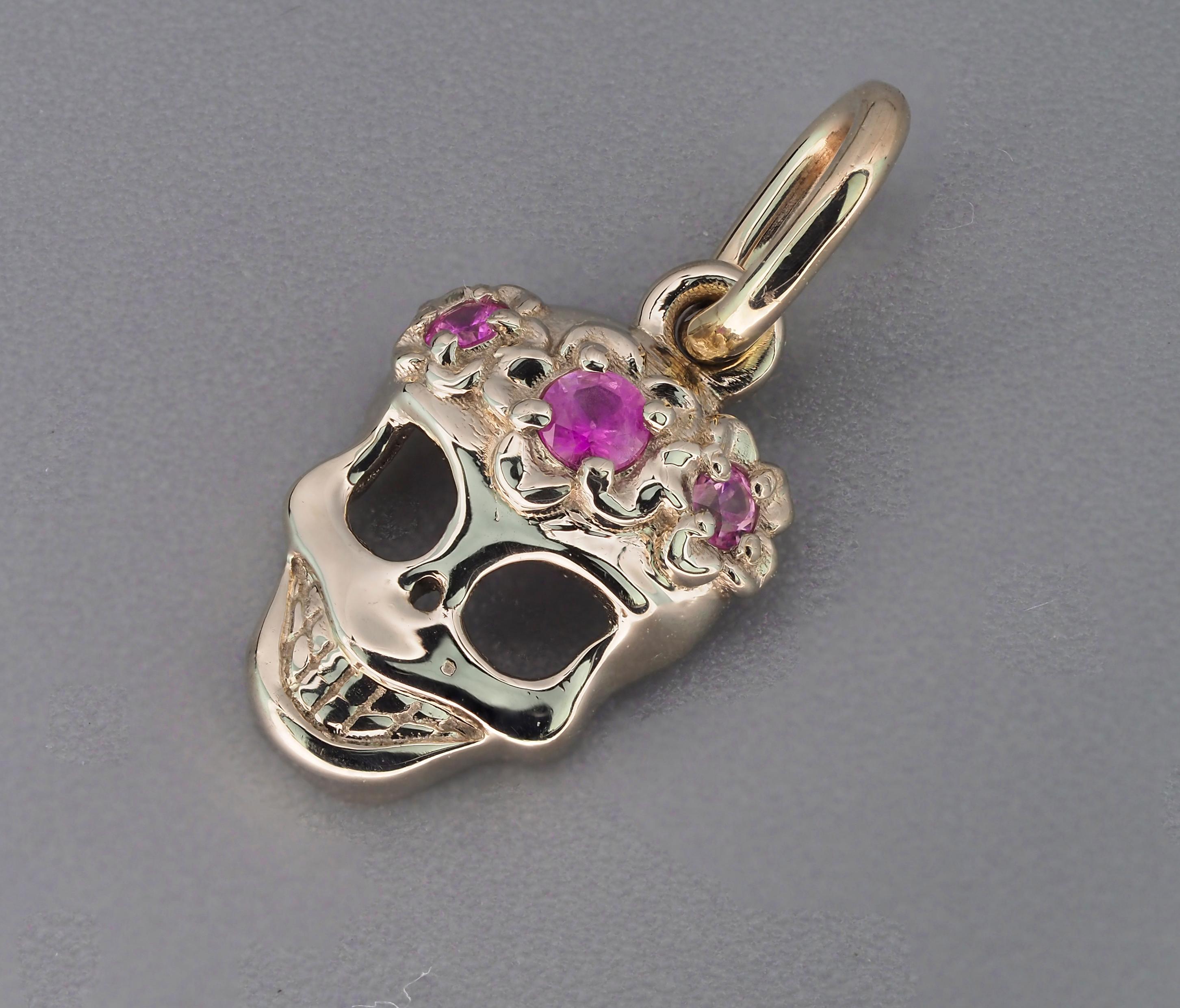 Gold skull pendant. 
Memento Mori gold charm pendant with sapphire. Pink sapphire pendant. Gold talisman charm. Halloween Skeleton pendant.

14k Gold white and yellow
Weight: 0.95 g
Size 16.3x8 mm.

Set with sapphires 3 - pink color, transparent,