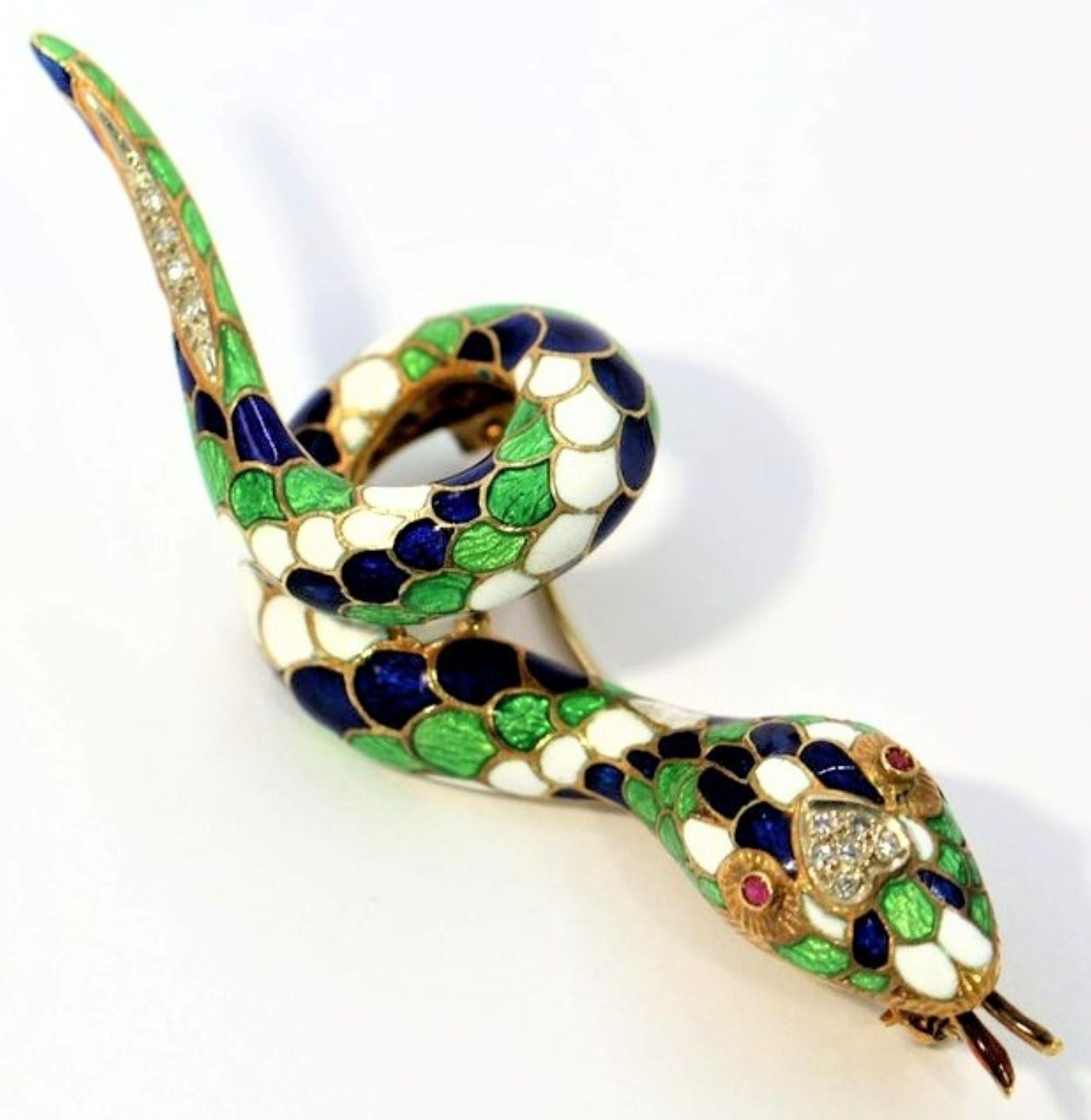 A gold, coiled, snake brooch with blue, green, and white enamel measuring one inch wide, and three inches long. The top of this serpent's head, and the tip of its tail are set with a total of 10 single cut diamonds weighing a total of approximately