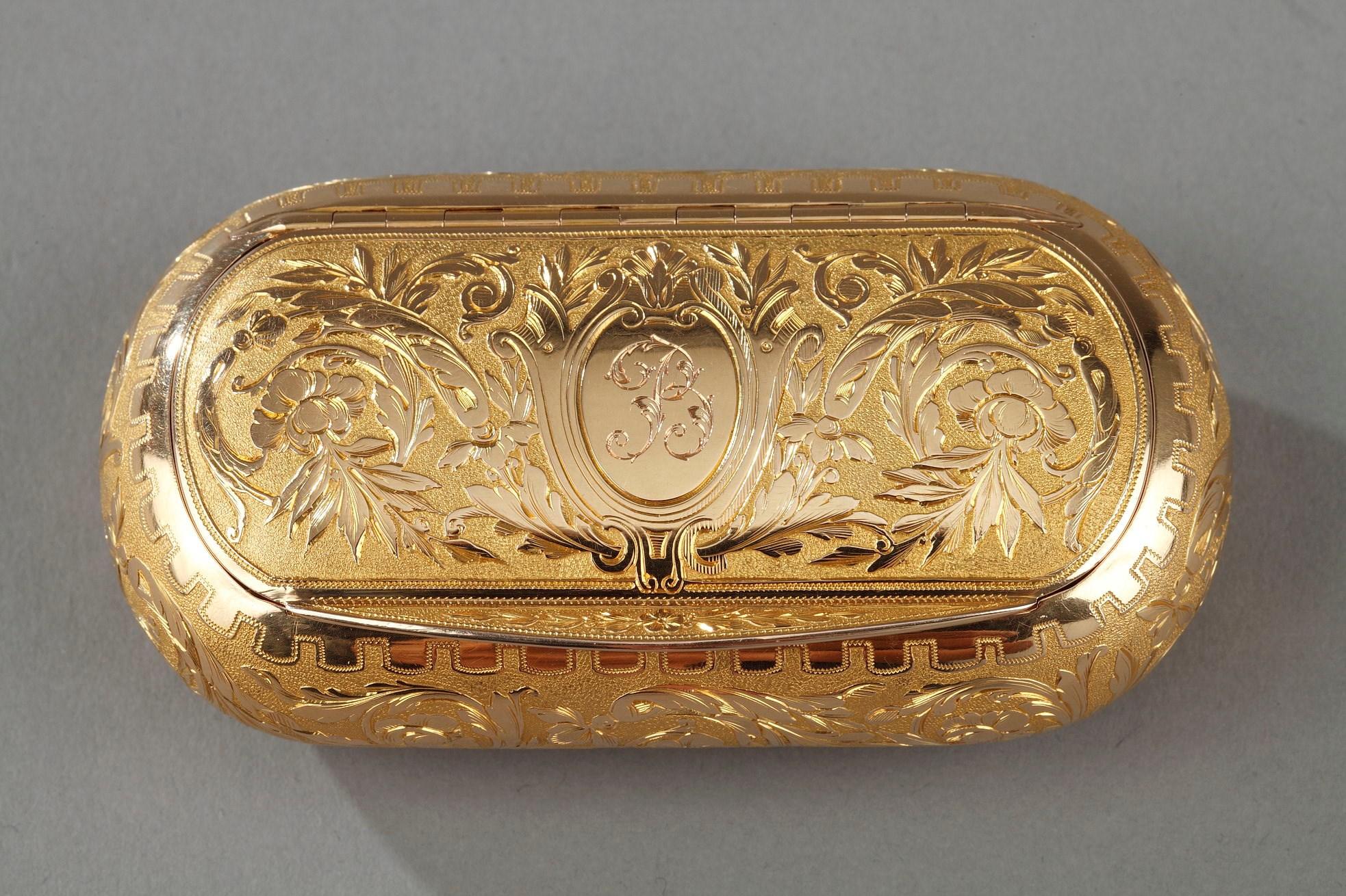 Golden snuff box oblong shape. The hinged lid is finely chiseled. The decor of foliage and flowers is organized on either side of a medallion central to the number B. The decor presents a game of Amati gold and bright gold characteristic of the