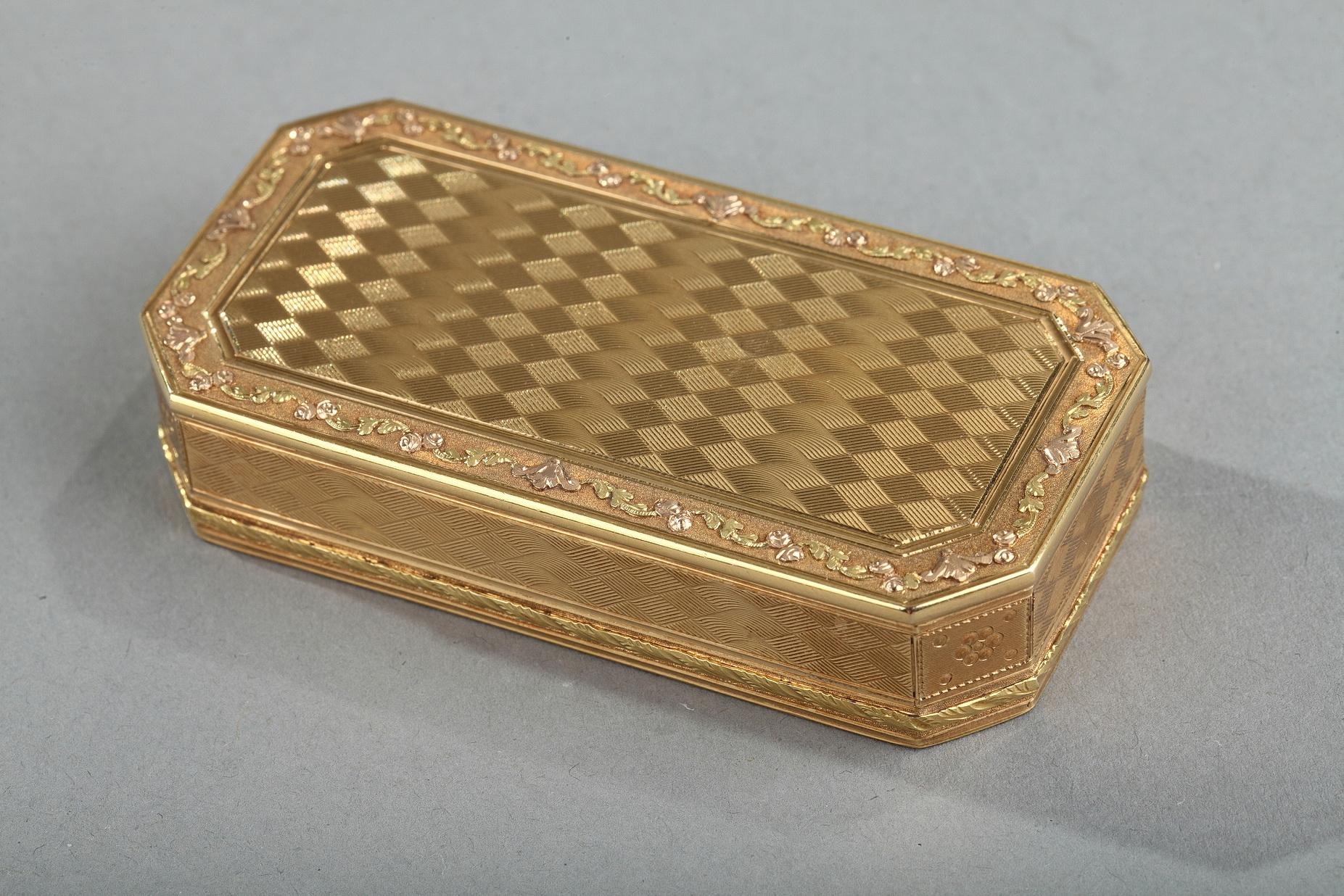 Rectangular snuffbox with angled corners sides. The box in several tons of gold presents an exceptional ‘guilloché’ decoration in lozenge reminding a work of basketry. This elegant work is framed by a stylized floral frieze with several shades of