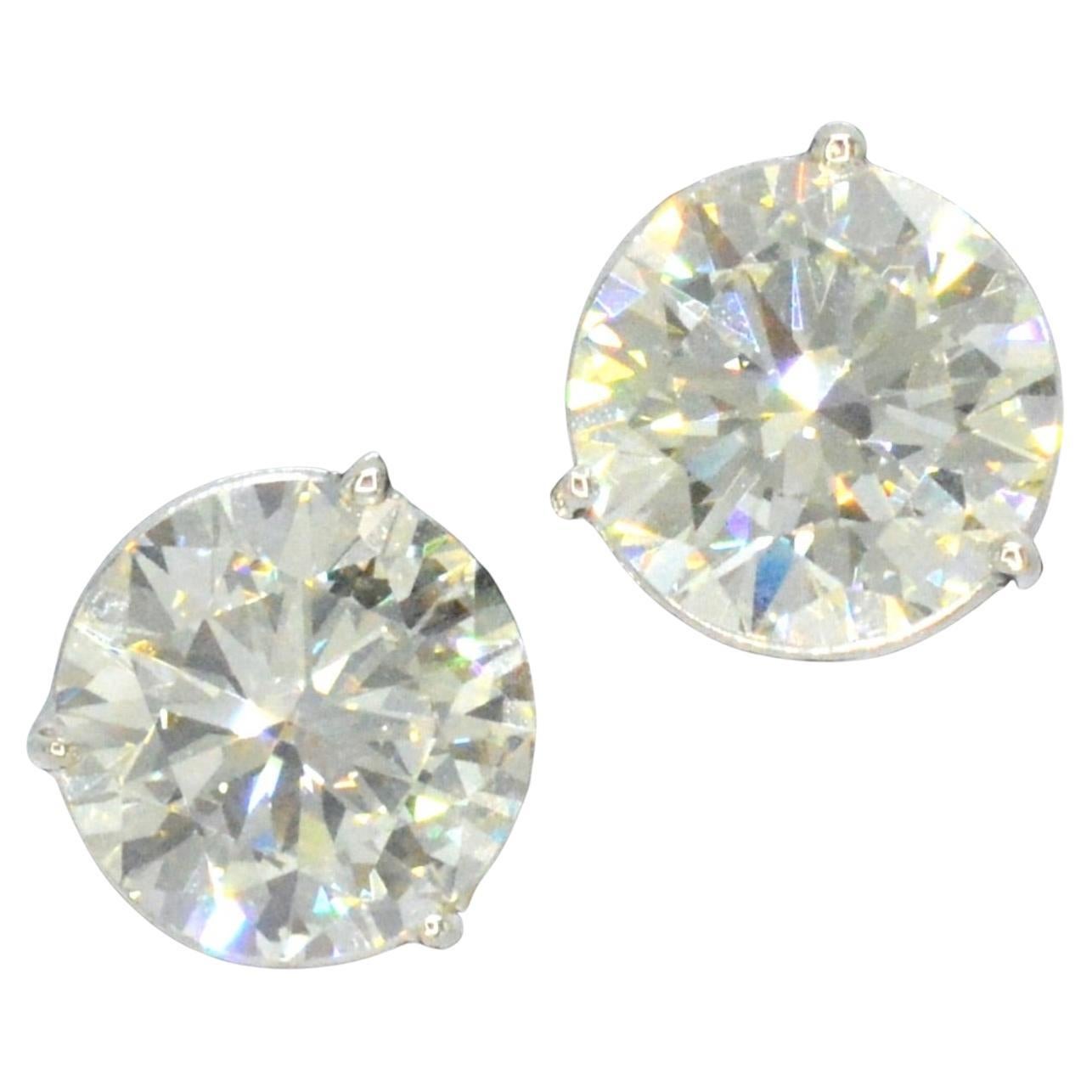 These exquisite stud earrings are a true statement piece. Each earring features a brilliant cut diamond weighing 5.00 carats, for a total of 10.00 carats. The diamonds have a warm tint with a K-L color grade and a VS clarity grade, and the grinding