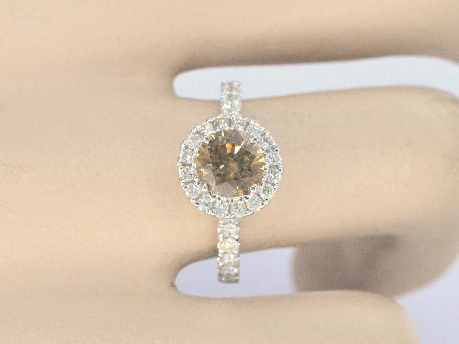 This ring features an elegant blend of diamonds and precious metals. It has one central diamond with a weight of 1.01 carats, cut in a brilliant shape, boasting a fancy cognac color and SI2 purity, with a grinding quality rated as very