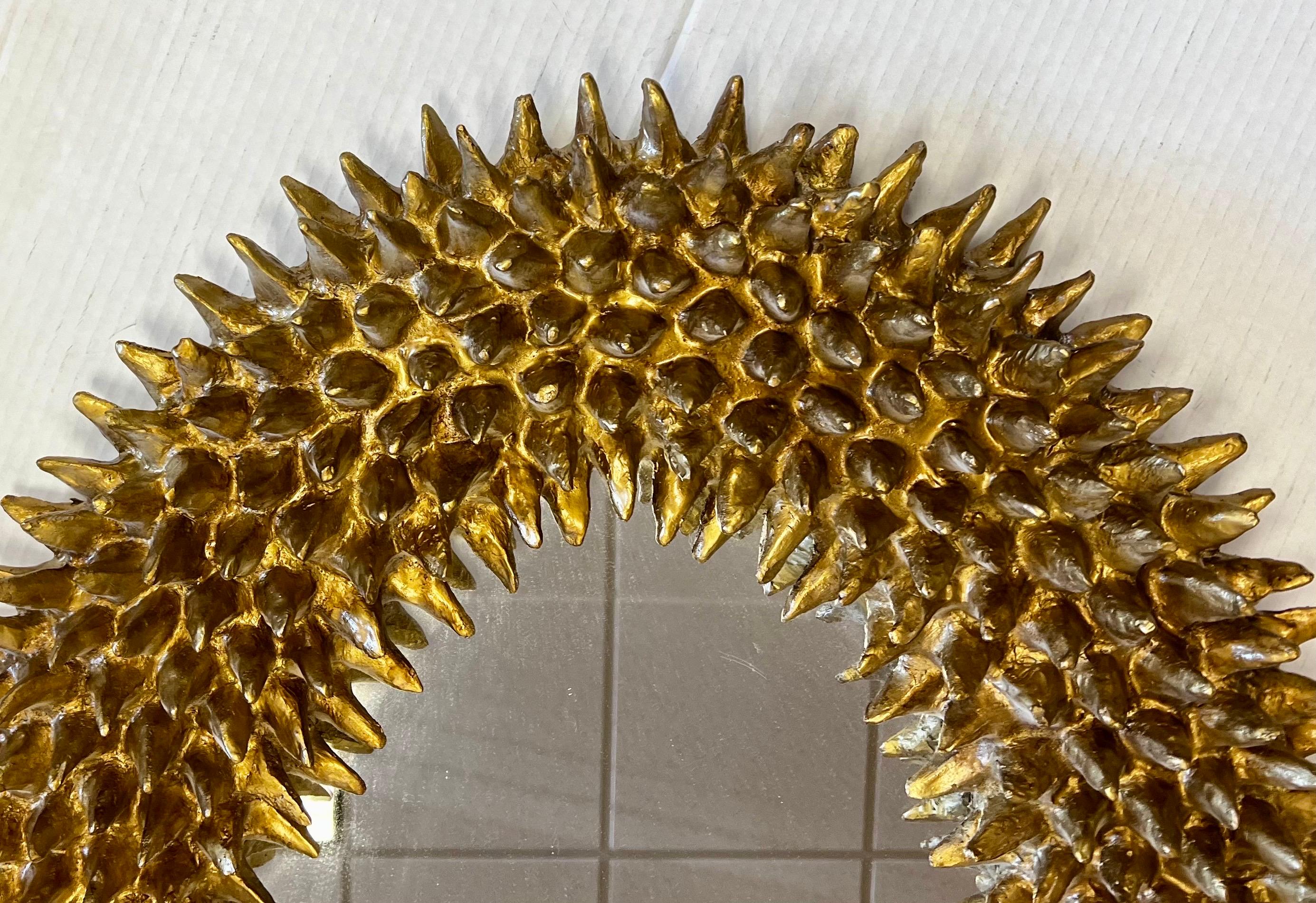 The Spore mirror, shown in antiqued gold leaf, was based on seed pods discovered in Barry Dixon’s yard.
The spore mirror is a faithful reproduction of a 60’s original papier-mache and wax piece found in Paris. The juxtaposition of the ornate gold