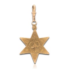 Gold star pendant engraved with foliate ornament. Dutch, late 17th century.