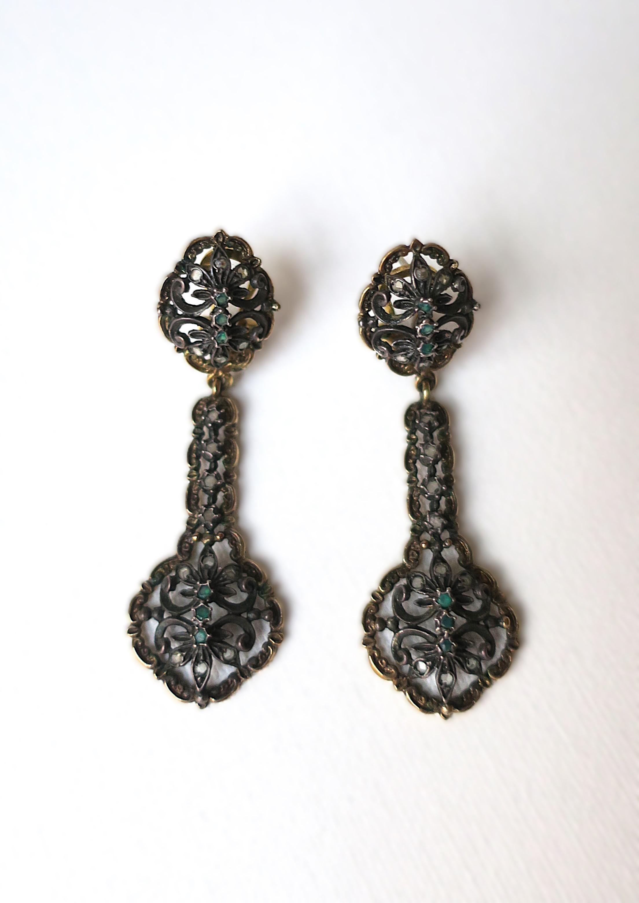 A beautiful pair of sterling silver, 14-karat gold, and emerald gemstone dangle drop earrings, in the Victorian style, circa late-20th century. A beautiful, well-made, one-of-a kind detailed pair of dangle drop earrings that can be dressed up or