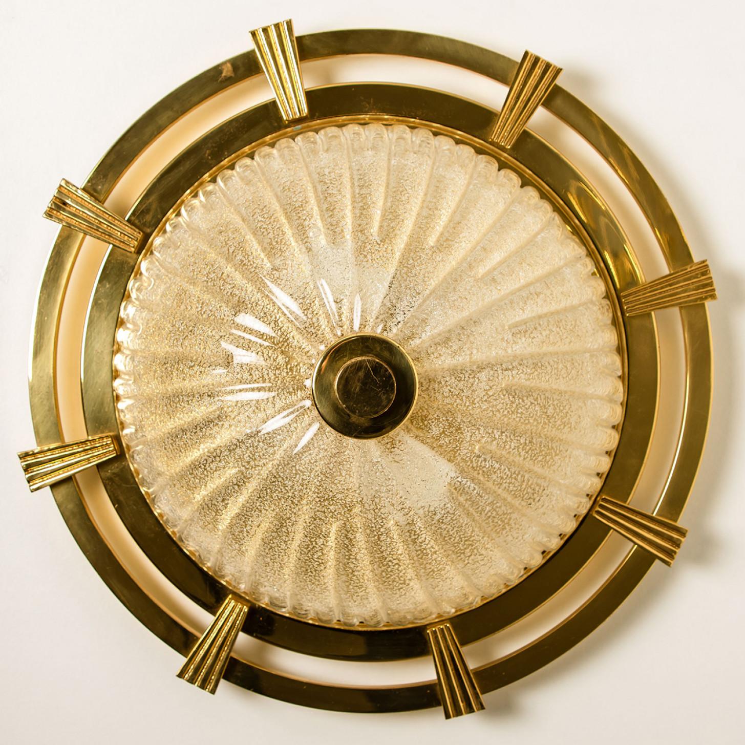 A wonderful round golden flush mount, circa 1970, made by Glashütte Limburg, Germany.
With hand blown textured glass on a gold base and a sun-like structure in gold. Illuminates beautifully.
Can either be mounted on the ceiling or on a