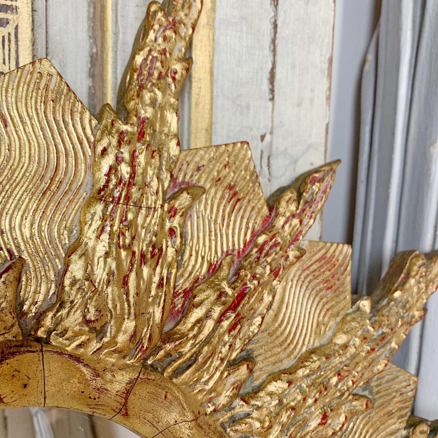 Miroir en bois doré sculpté à la main, très décoratif et inhabituel, datant des années 1960, avec plaque de miroir d'origine. De grandes proportions, il s'agit d'un miroir au soleil du milieu du siècle au design très inhabituel. 

Mesures : largeur