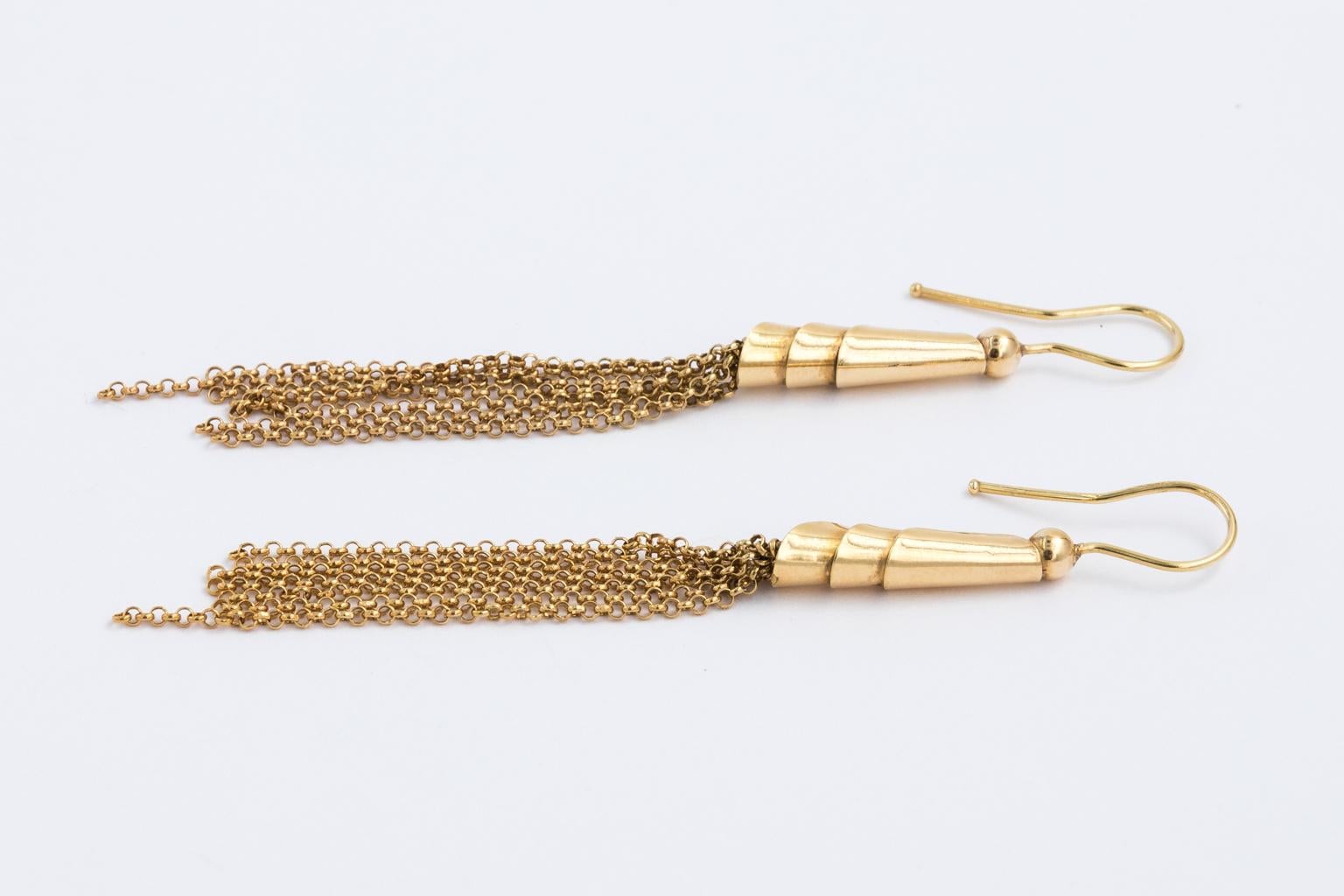 Circa 1980s 18 Karat Gold tassel earrings from Italy. The earrings are pierced with a French wire technique and hang 3.00 Inches long with one tassel slightly longer for added style. Holding the tassels are hollow barrel shapes with three layers.
