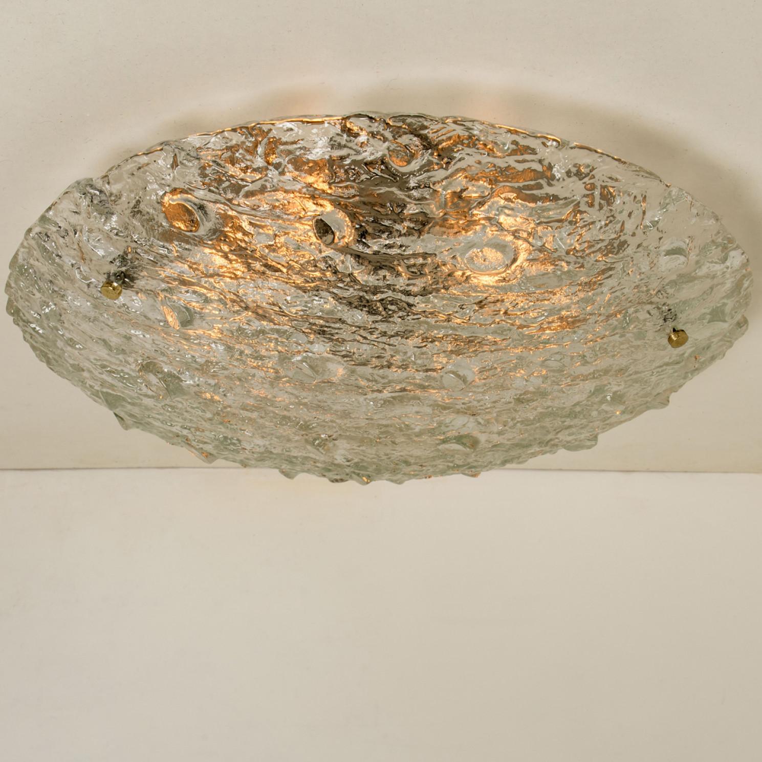Beautiful high quality light fixture made by Kaiser Leuchten, Austria. Manufactured in mid century, circa 1970 (at the end of 1960s and beginning of 1970s).

This wall light features lights made of handmade wave-textured glass with gold effects. The