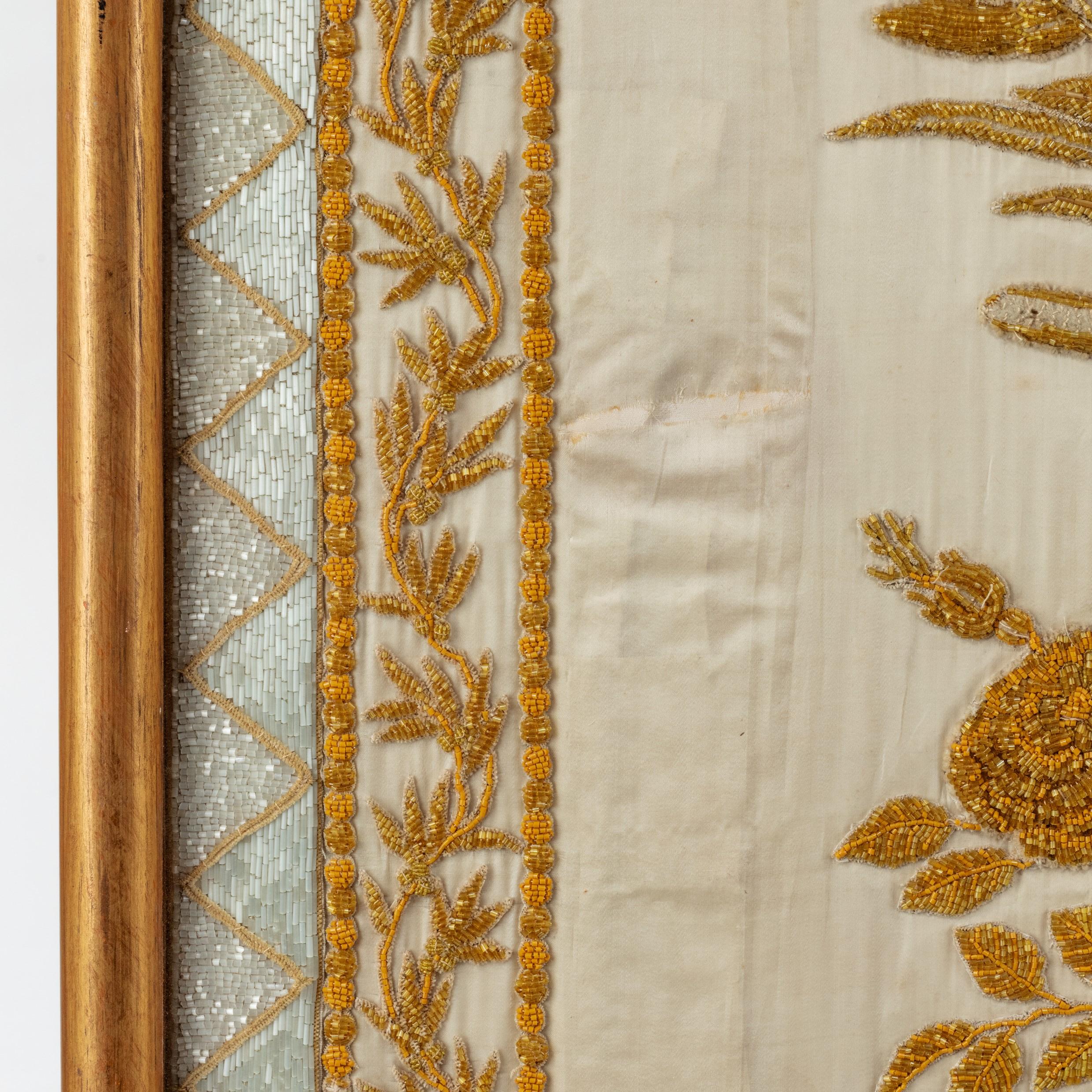 A gold thread embroidery of Royal French interest, of rectangular form with a central roundel of entwined initials beneath a crown and pendant foliage, all above a beribboned floral garland, worked in gold thread, seed pearls and glass beads,