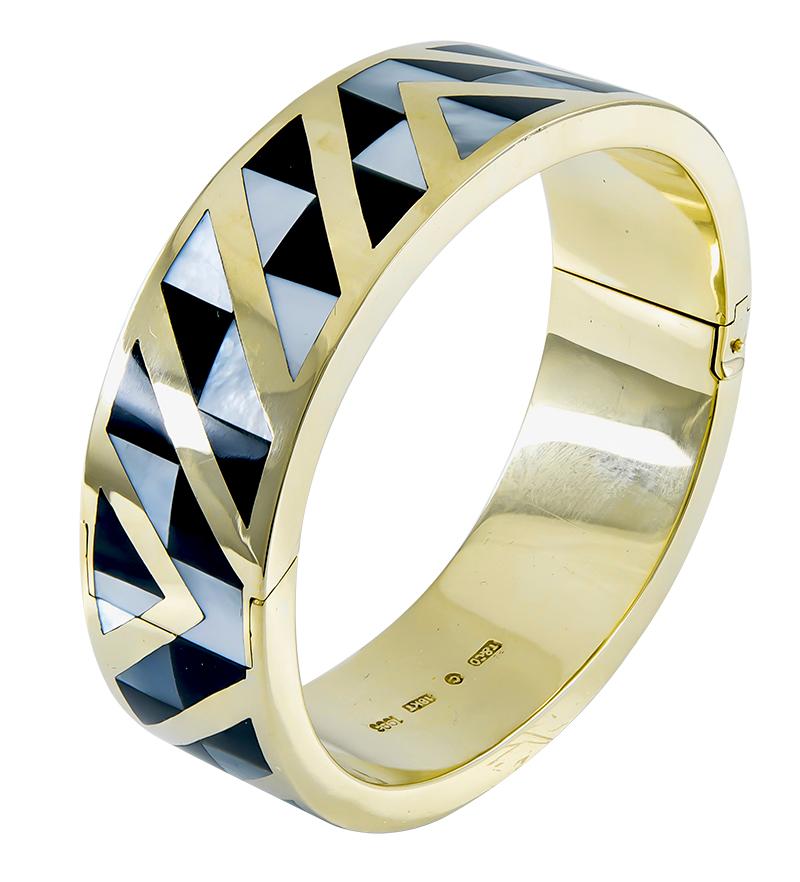 A very compelling piece of jewelry:  a hinged bangle bracelet.  Made and signed by TIFFANY & CO.  Set with black jade and mother-of-pearl in a striking geometric pattern. The pattern is seamless, and continues around the bracelet, front and back.