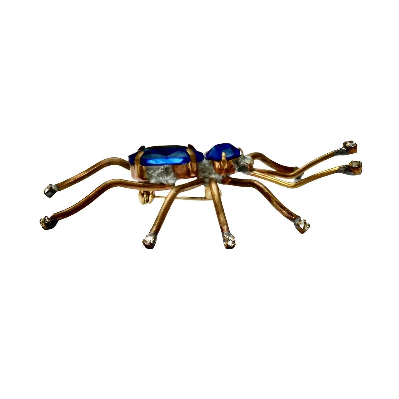 Amazing gold tone spider brooch with blue rhinestones for the body and clear rhinestone eyes. The legs and antennae finish with small clear rhinestones. The brooch has been individually handmade. Measuring length 7.6 cm / 3 inches by width 5.2 cm /