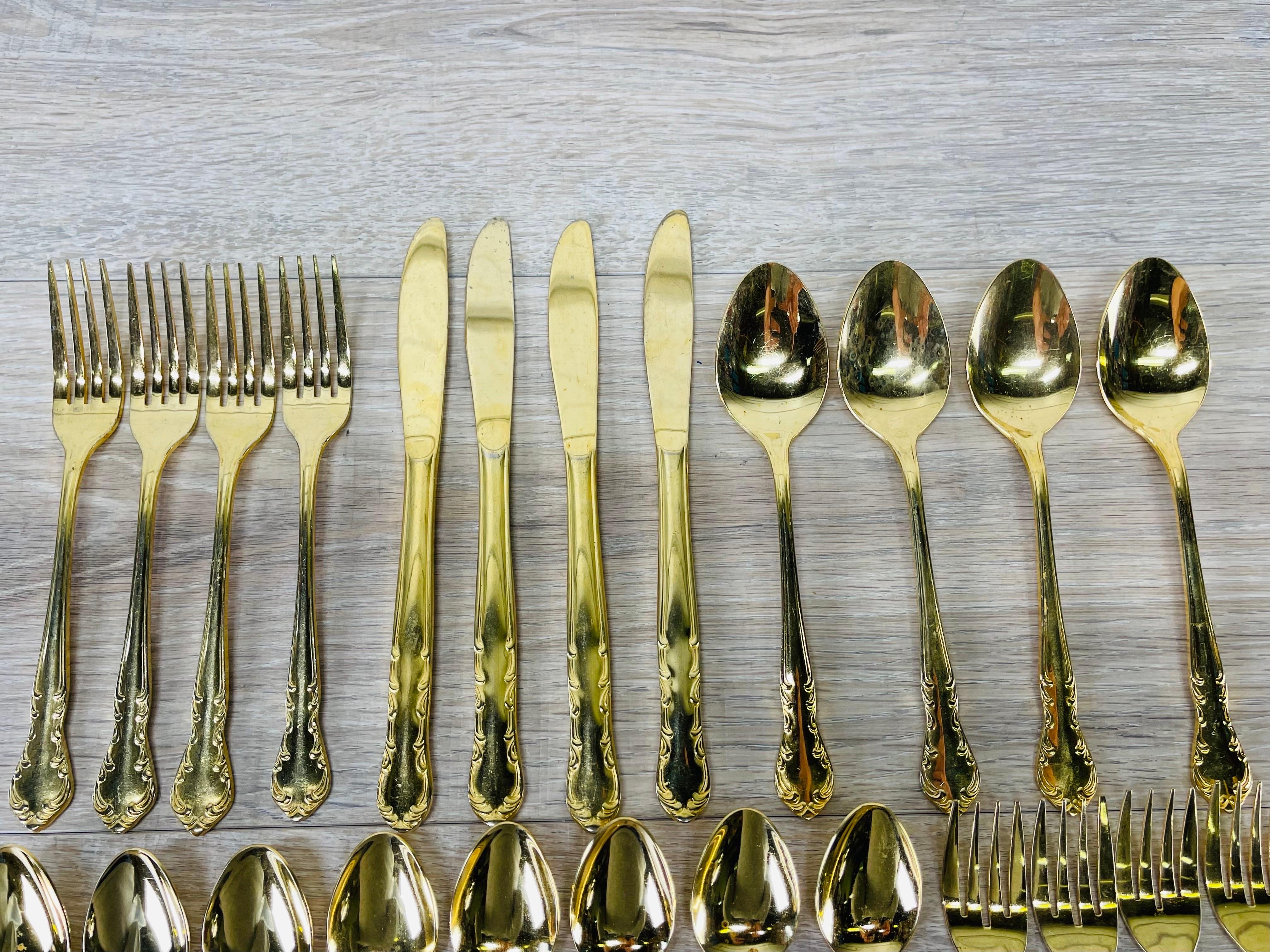 Vintage set of 24 pieces of flatware with a scroll design. This is a complete set of four with additional pieces. There are 4 knives, 4 dinner forks, 4 salad forks, 4 tablespoons and 8 teaspoons. No marks. Light wear to the gold tone in spots from