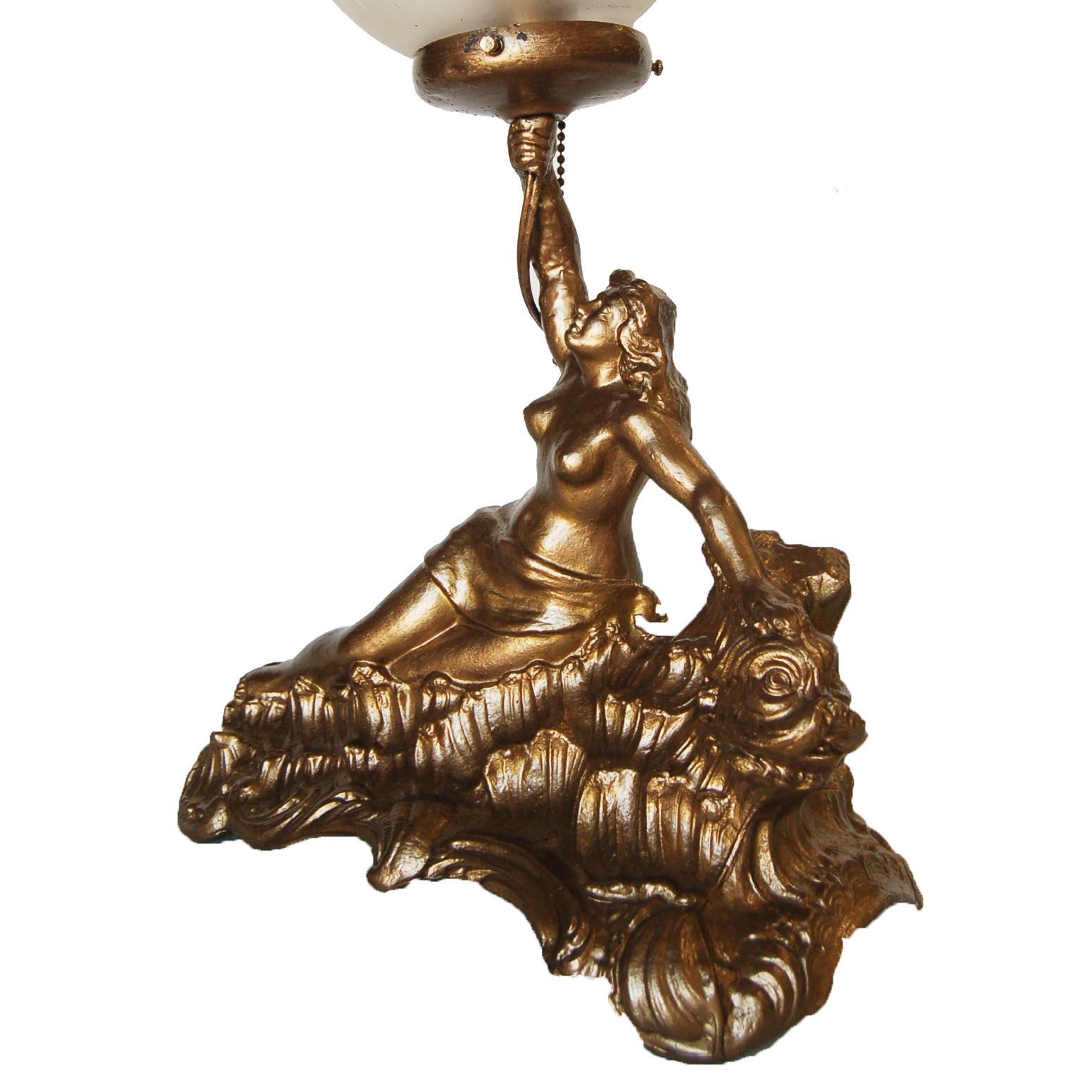 Gold-toned Grecian lounging female spelter metal lamp with ornamental cut crystal glass globe. 

Measures: 12