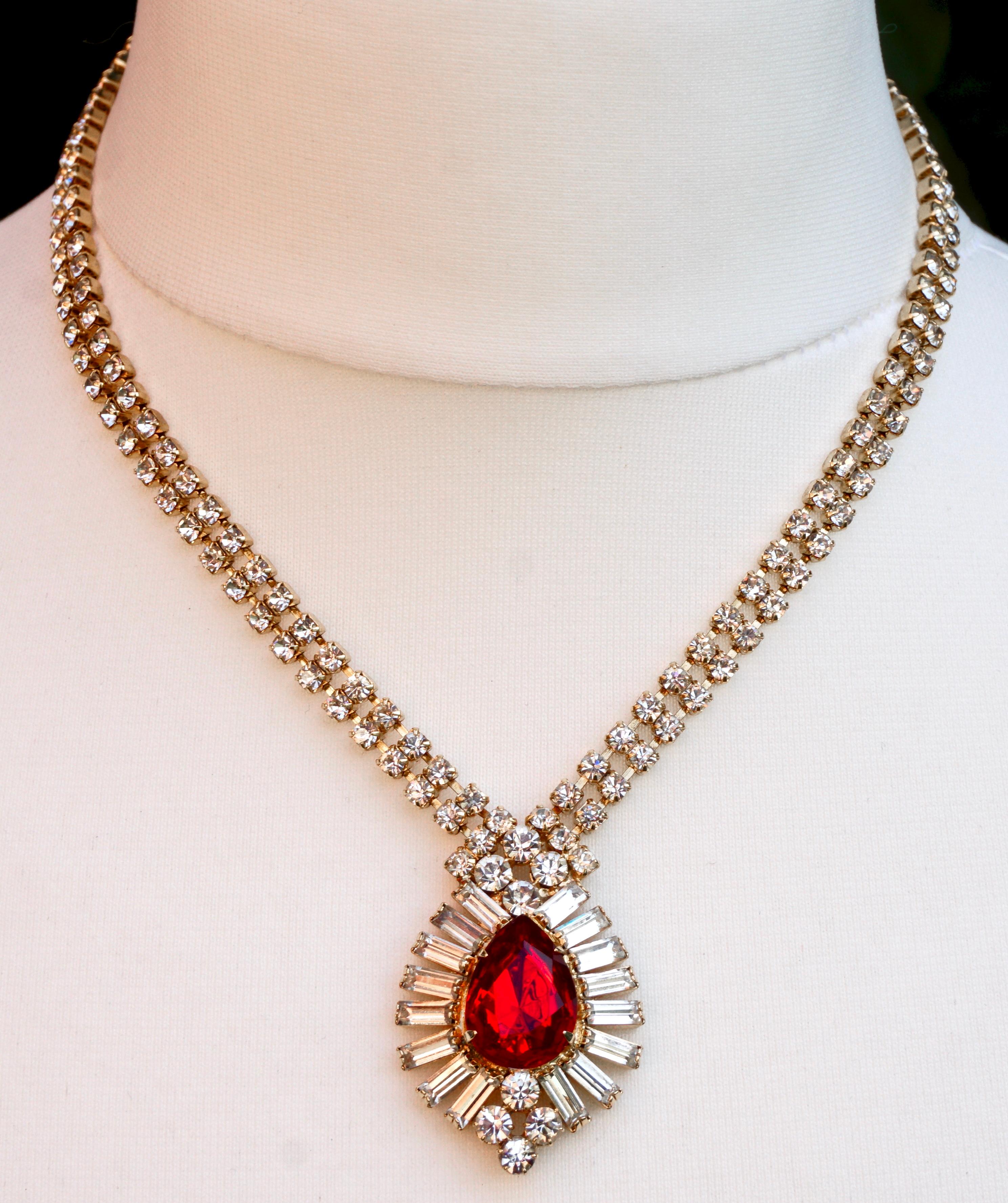 Gold tone pendant necklace featuring clear baguette and round rhinestones, and the pendant is set with a lovely red teardrop rhinestone. The necklace measures length 43.18cm / 17 inches by width 6mm / .24 inch. The pendant is length 4cm / 1.57