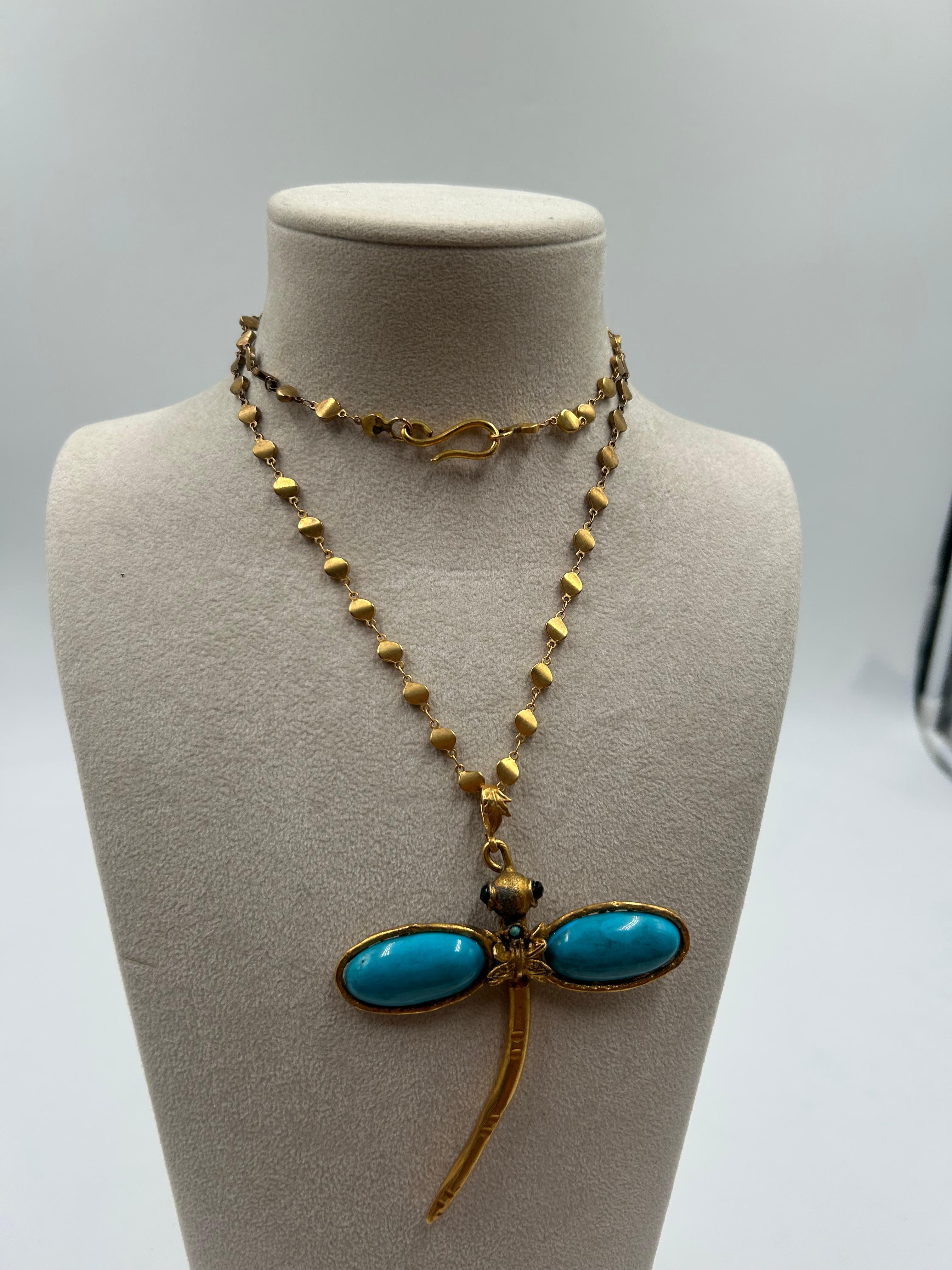 Whimsical and bold, this gold-toned brass statement necklace features a striking blue enamel dragonfly centerpiece, accented with intricate detailing and vibrant color. The sculptural design adds a touch of nature-inspired elegance, while the rich