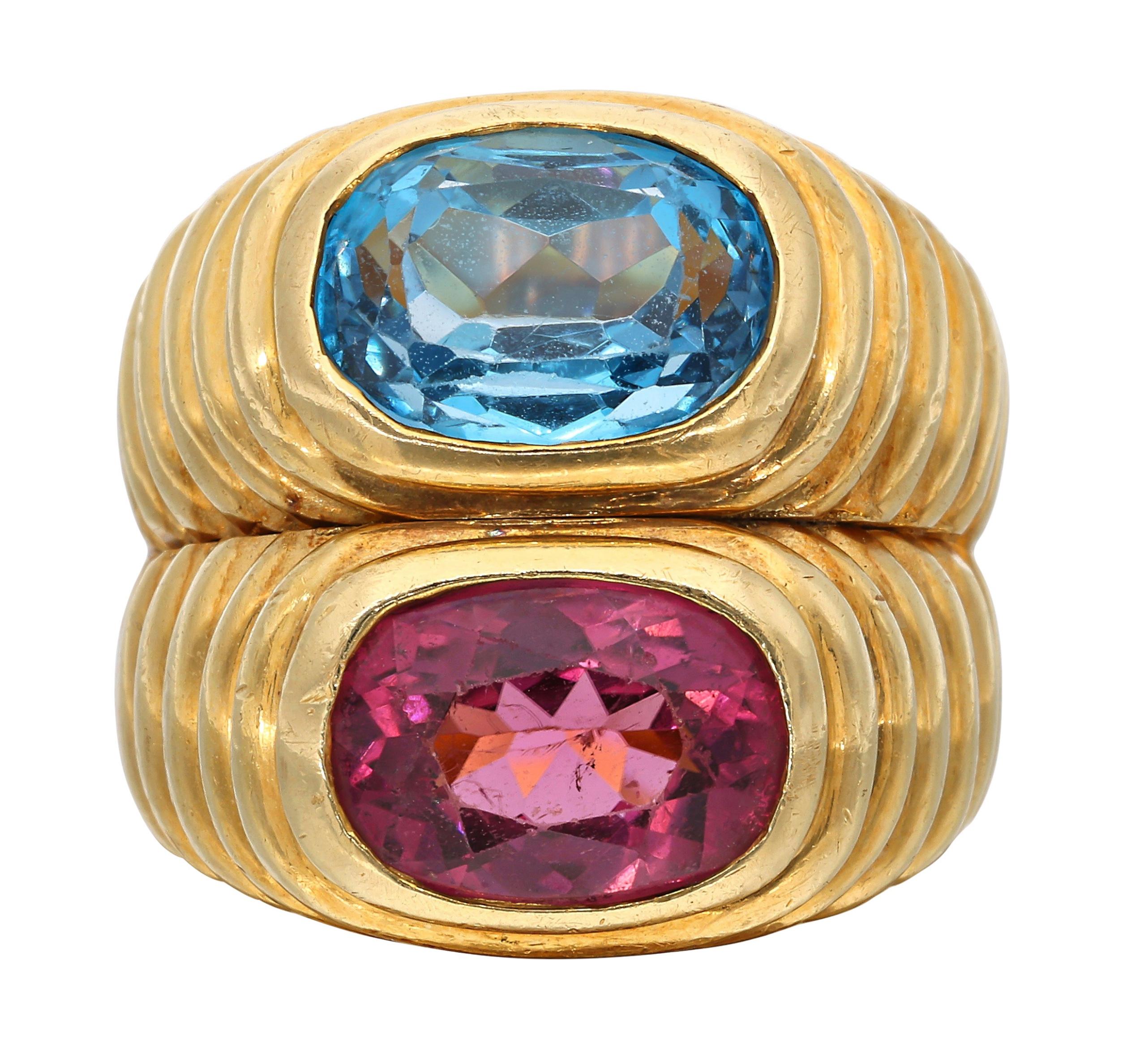 This playful ring features one oval shaped topaz and one oval shaped tourmaline.

- Topaz weighs approximately 3.50 carats
- Tourmaline weighs approximately 3.00 carats
- 18 karat yellow gold
- Total weight 21.37 grams
- Size 6

The condition report