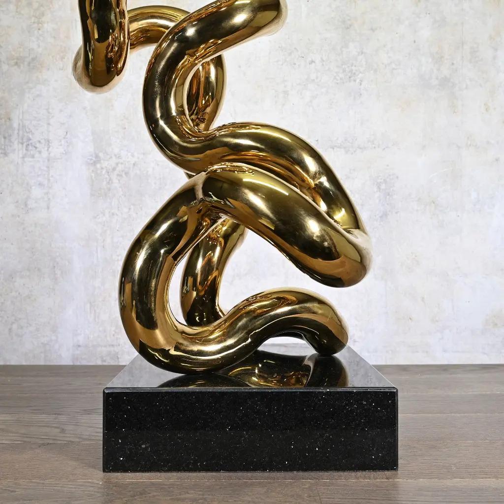 Goldfarbene röhrenförmige Metallskulptur auf schwarzem Sockel, zeitgenössischer Stil (Französisch) im Angebot