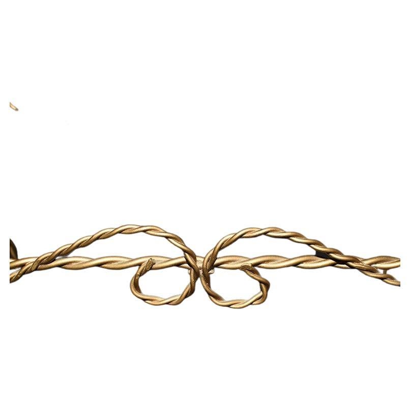 Una piccola mensola da parete appesa creata in metallo dorato e ritorto. Questo scaffale è ideale in un bagno per contenere prodotti di bellezza o piccoli oggetti decorativi. Ciascuna delle due mensole è realizzata in vetro ed è rimovibile.