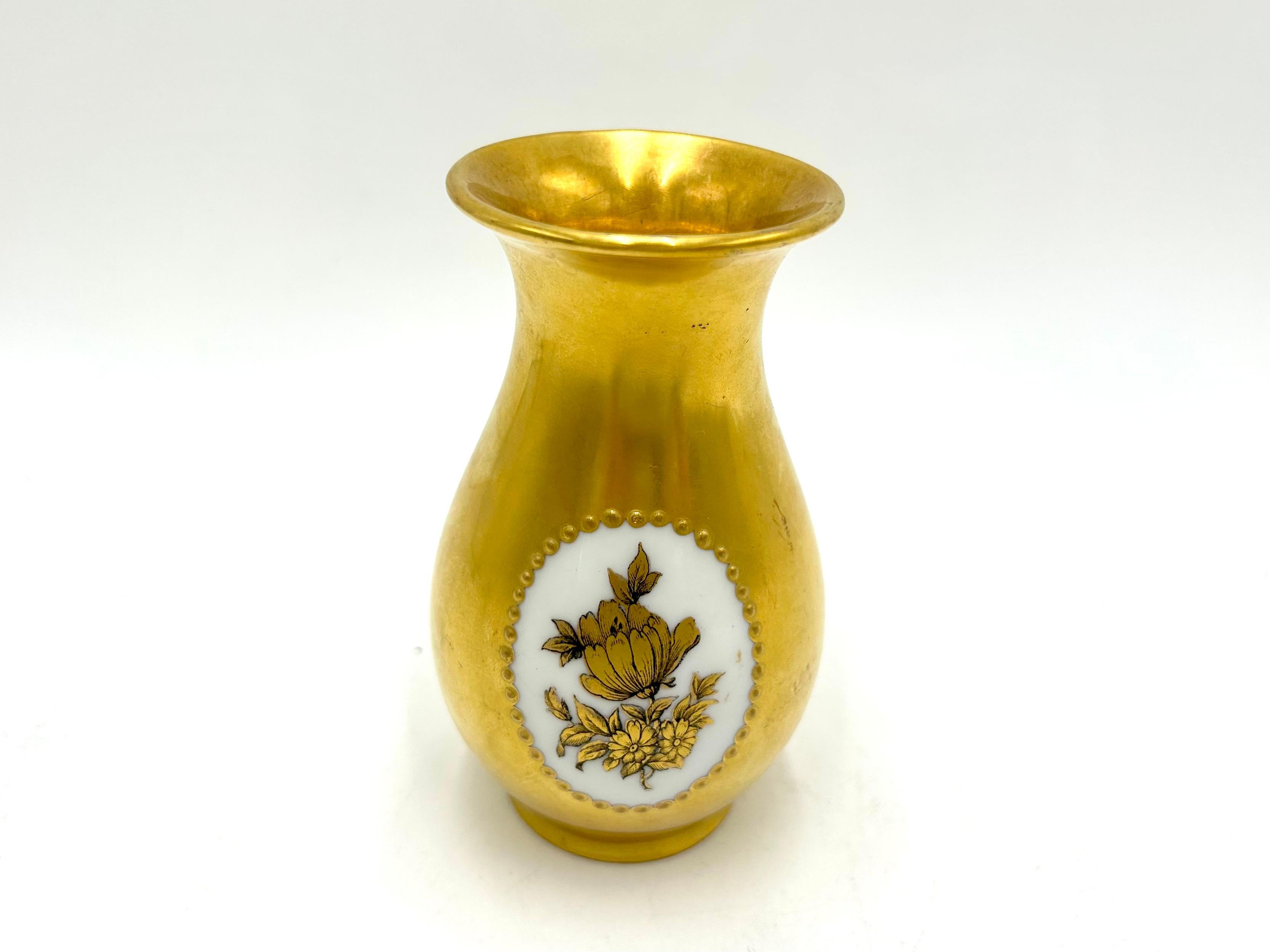 A unique vase from the renowned German manufacturer Rosenthal.
The product is entirely covered with gilding, on one side decorated with a golden flower on a white background.
The vase was produced around 1930.
Very good condition, no