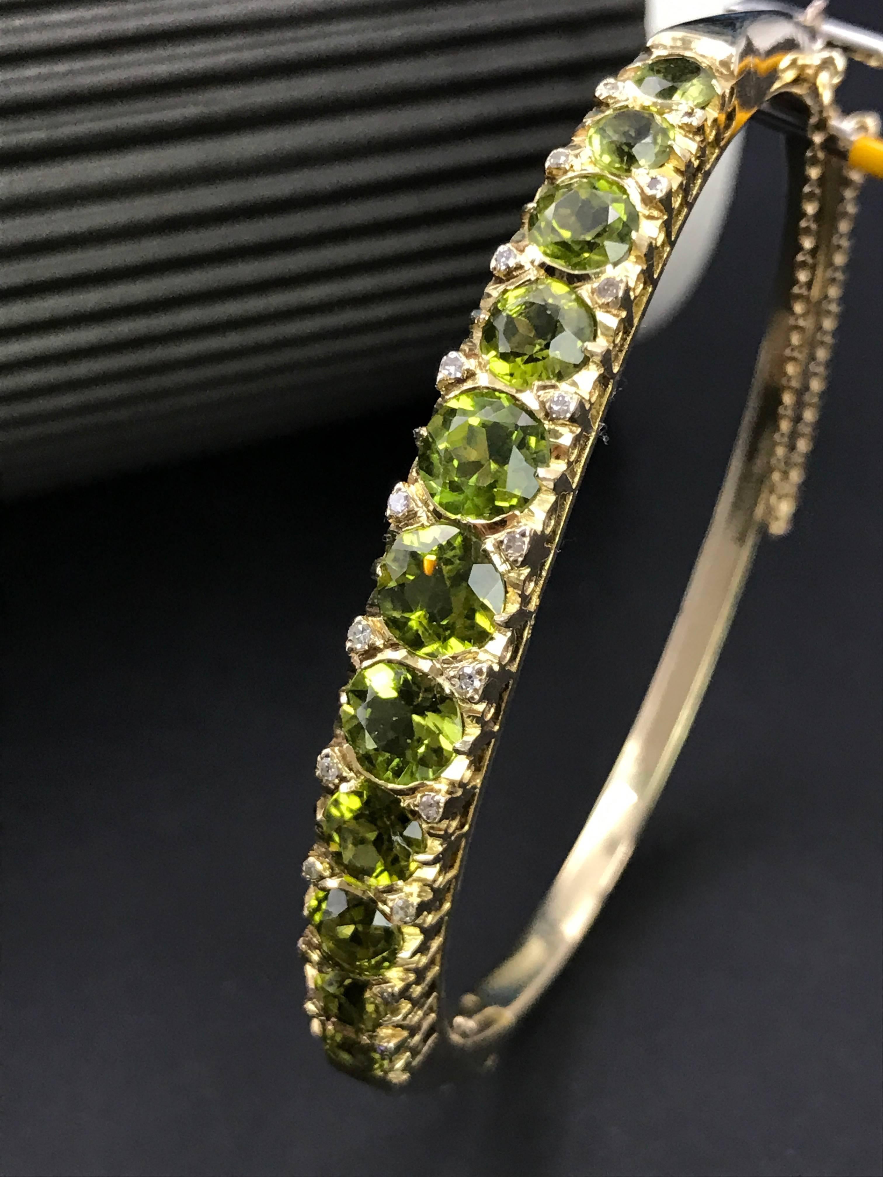 A Victorian 9 karat gold hinged bangle bracelet with peridot and diamonds. The bangle bracelet has 11 peridots with an approximate total weight of 5.3 carats set in a graduated line, 20 brilliant cut diamonds with an approximate total weight 0.5