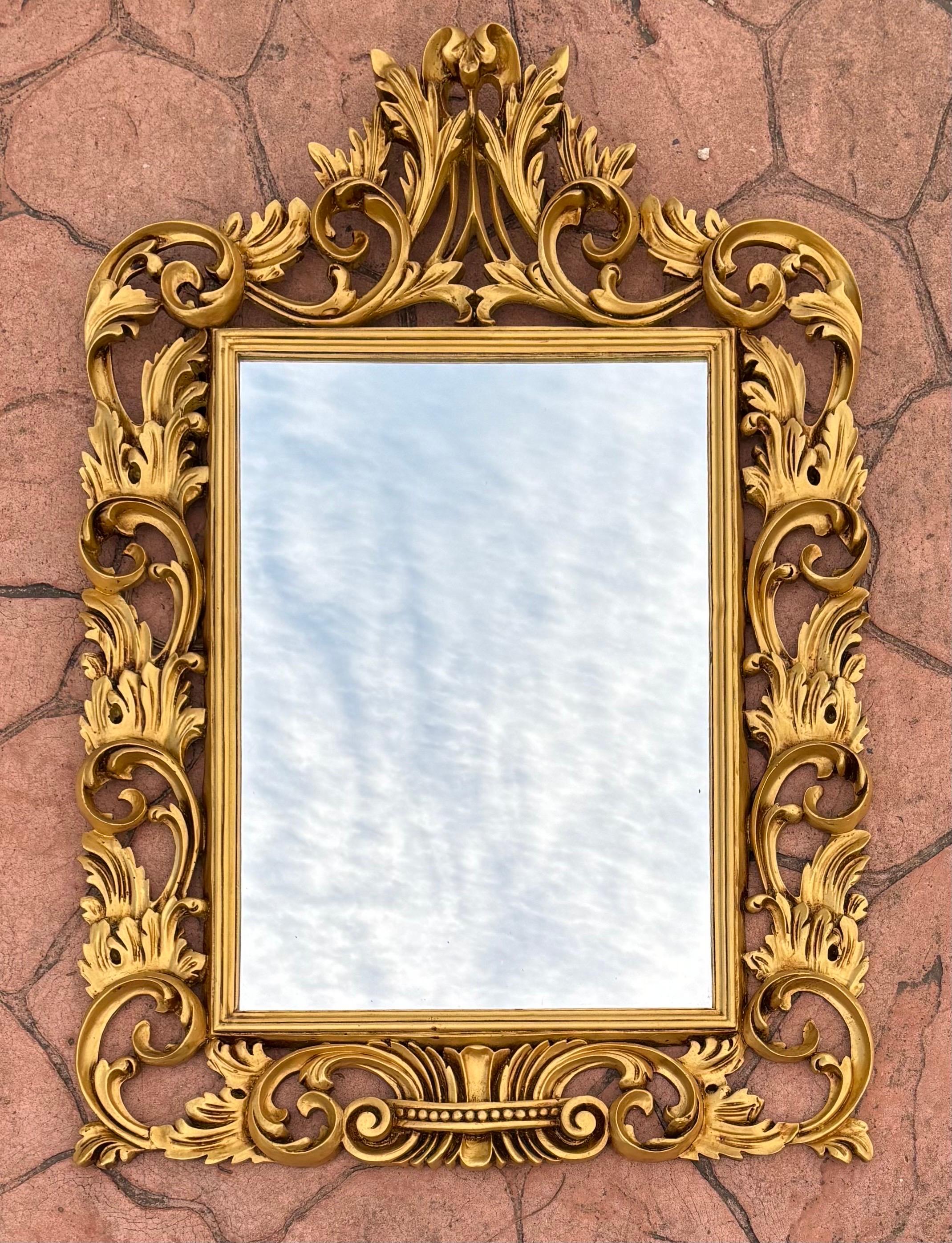 Ce miroir orné reflète le style rococo popularisé en Europe au cours du XVIIIe siècle, caractérisé par ses lignes courbes, ses motifs asymétriques et son abondante décoration. Le cadre présente des sculptures élaborées avec des motifs floraux et des