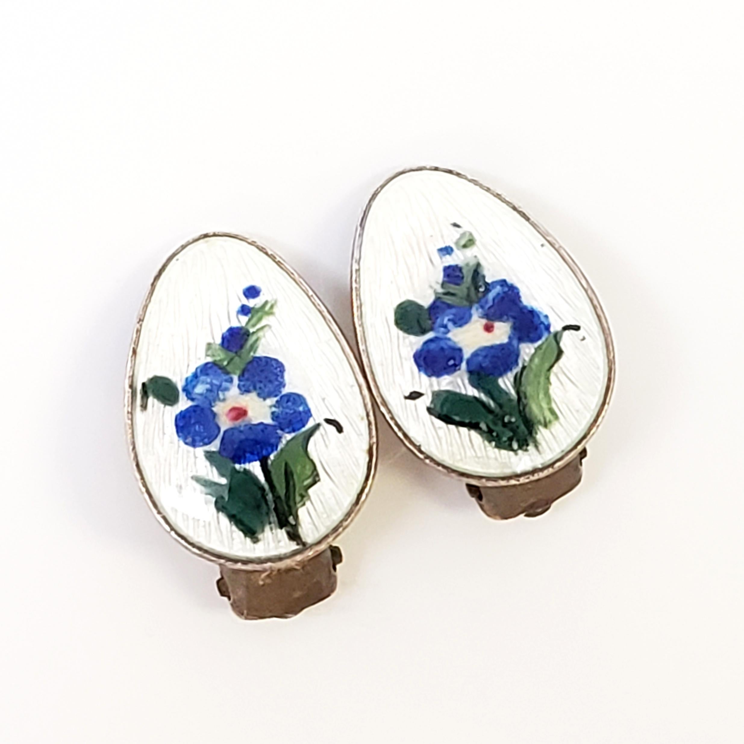 Vintage gold vermeil over sterling silver white guilloche enamel flower clip-on earrings by Ivar T Holth.

Beautifully hand painted flowers on white guilloche enamel with a gold wash and clip-on backing. It is a beautiful example of Ivar Holth's