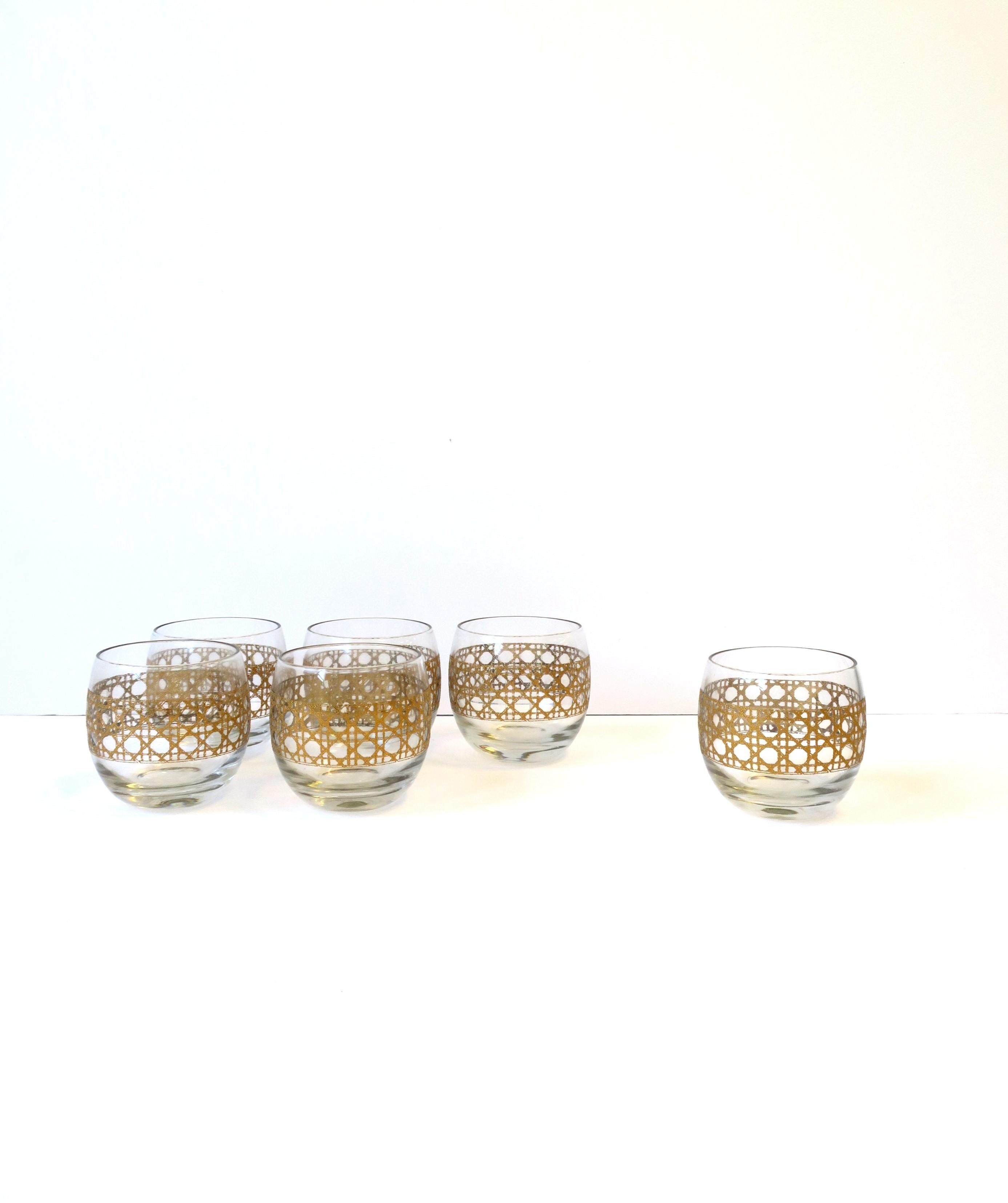 A set of six (6) gold wicker 'cane' round tumbler rocks' cocktail glasses, circa 1960s, mid-20th century, USA. Glasses are round tumbler rocks' cocktails glasses with a gold wicker cane pattern around exterior. A great set for any bar, bar cart,