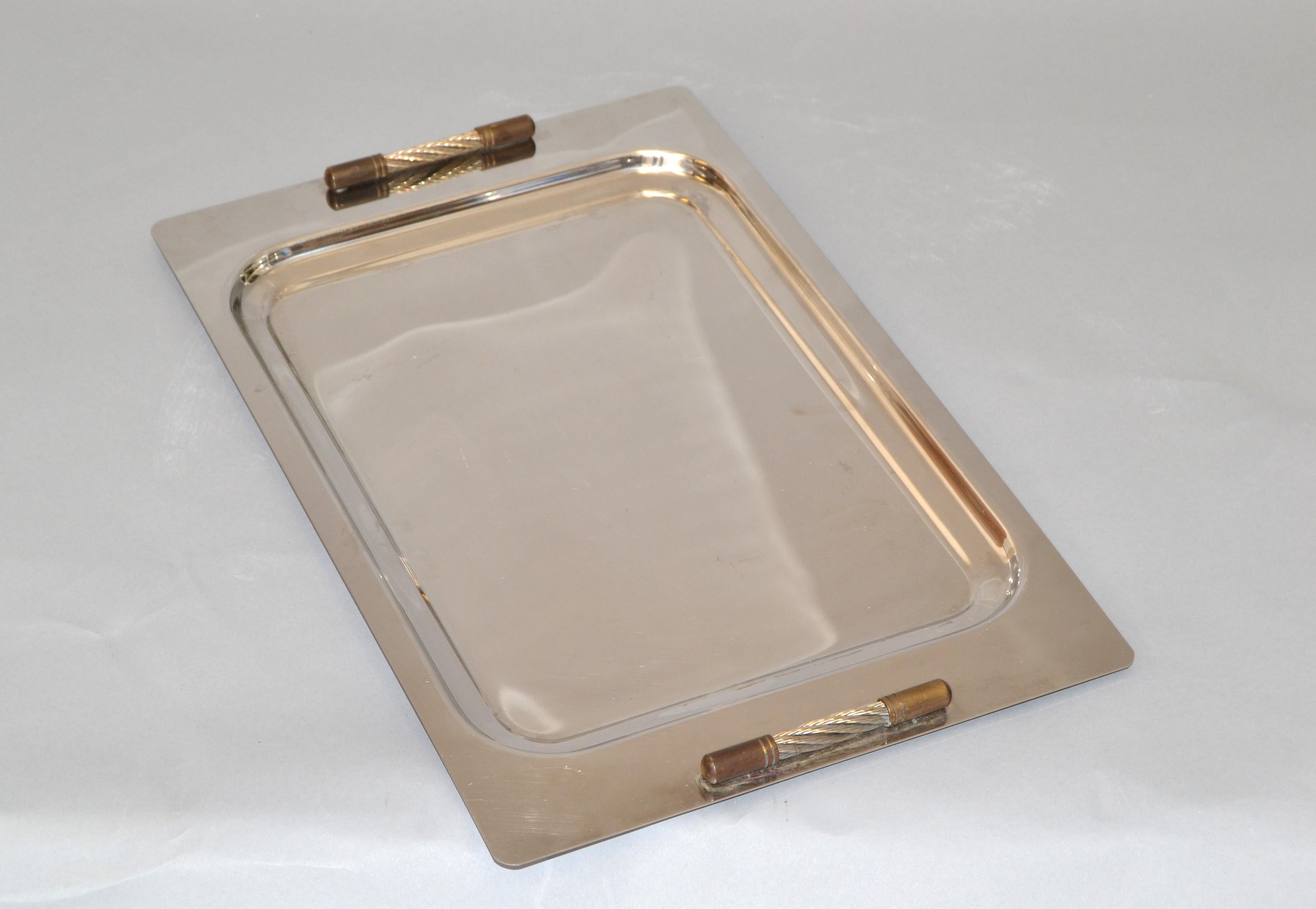 Mid-Century Modern decorative serving tray or platter made out of stainless steel with brass handles made in Argentina by Golden Art Steel Design. 
Serving Space is 12 x 8.5 inches.
Makers Mark on the reverse, 18/8 Inox.
 