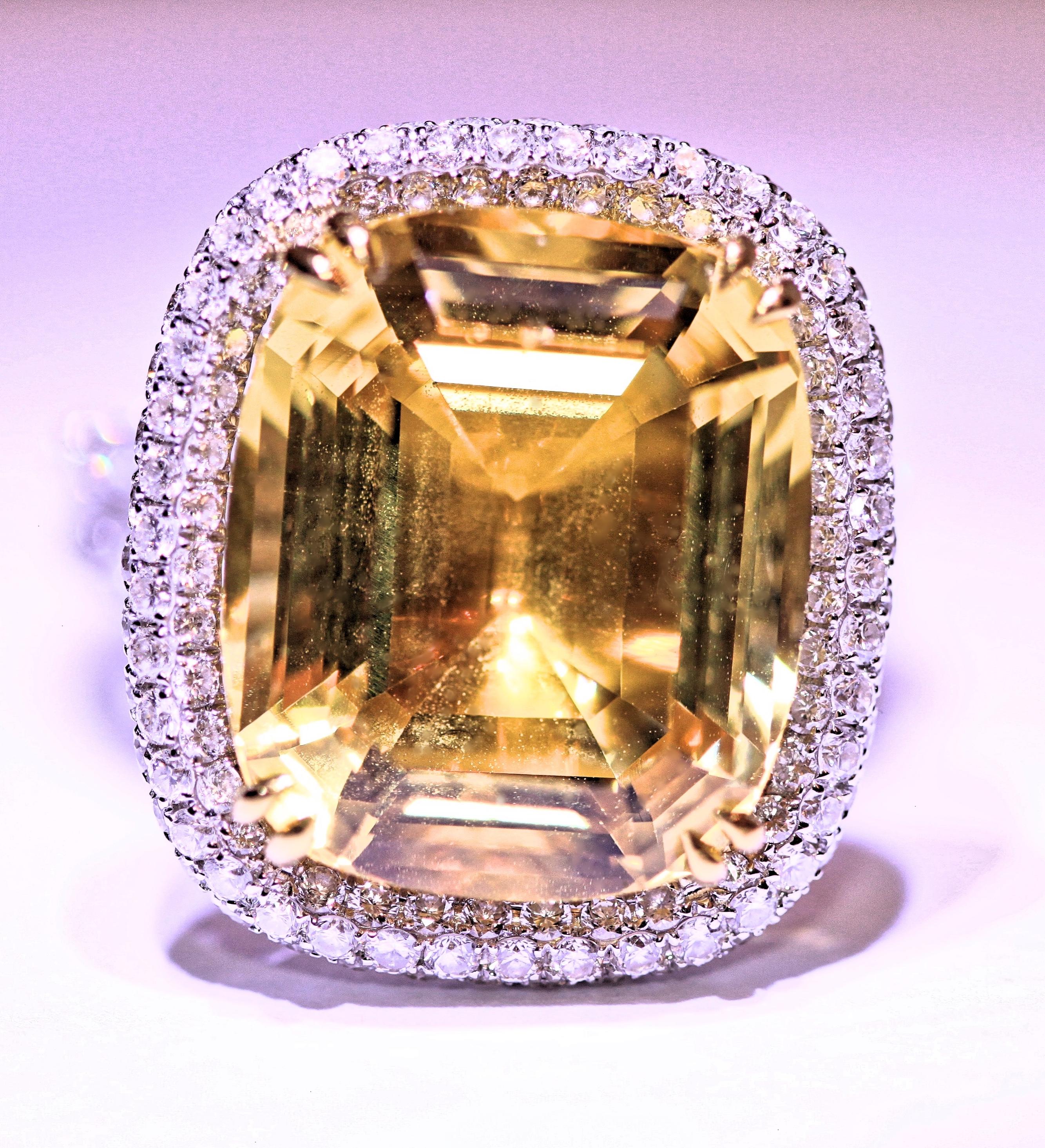 This piece is an amazing and artfully crafted golden beryl, 18 karat white gold and diamond ring. The beryl is a step cut stone that's approximately  13 carats total weight . The Beryl measures 16 x 13 mm and it is surrounded by beautiful, white