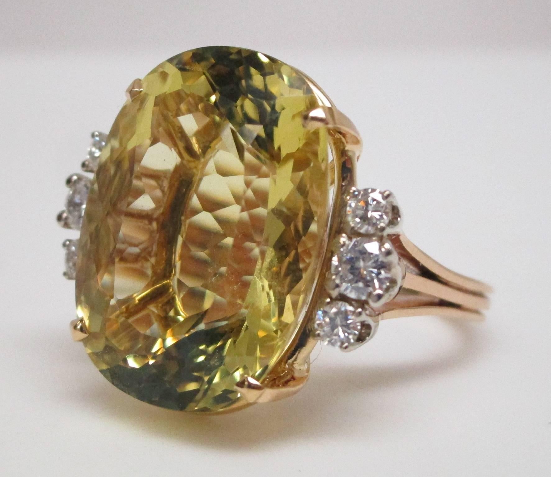 The golden beryl looks like a drop of sunshine captured between competing rows of moonlight, the diamonds. It has impressive size, being 16.38 carats, with 0.36 carats total in diamonds. The setting is 18K yellow gold. People will not miss seeing