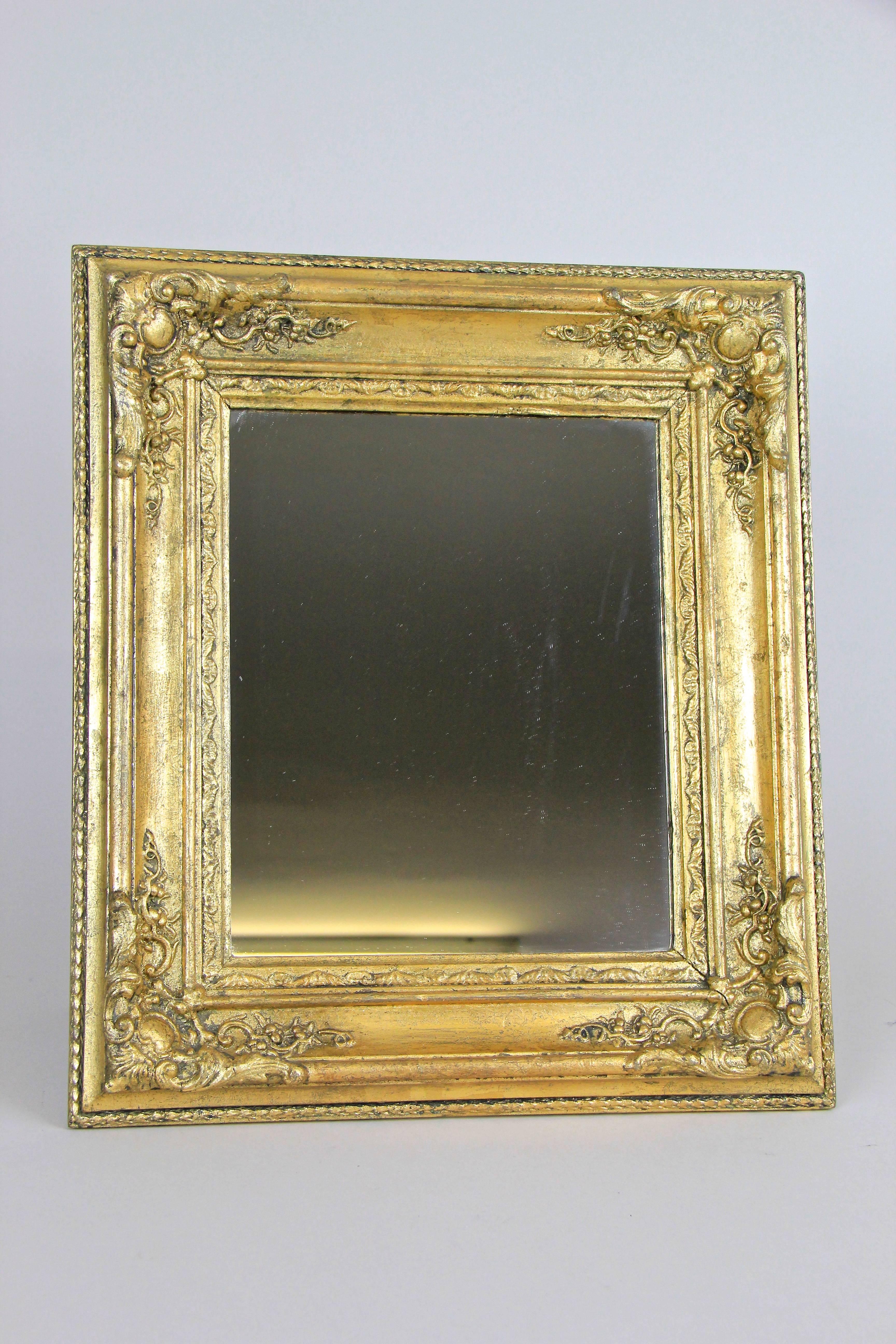 Beautiful golden Biedermeier wall or table mirror from the late Biedermeier period in France, circa 1860. This lovely small mirror or table mirror comes in absolute great original condition, only the old mirror glass was renewed. The broad frame
