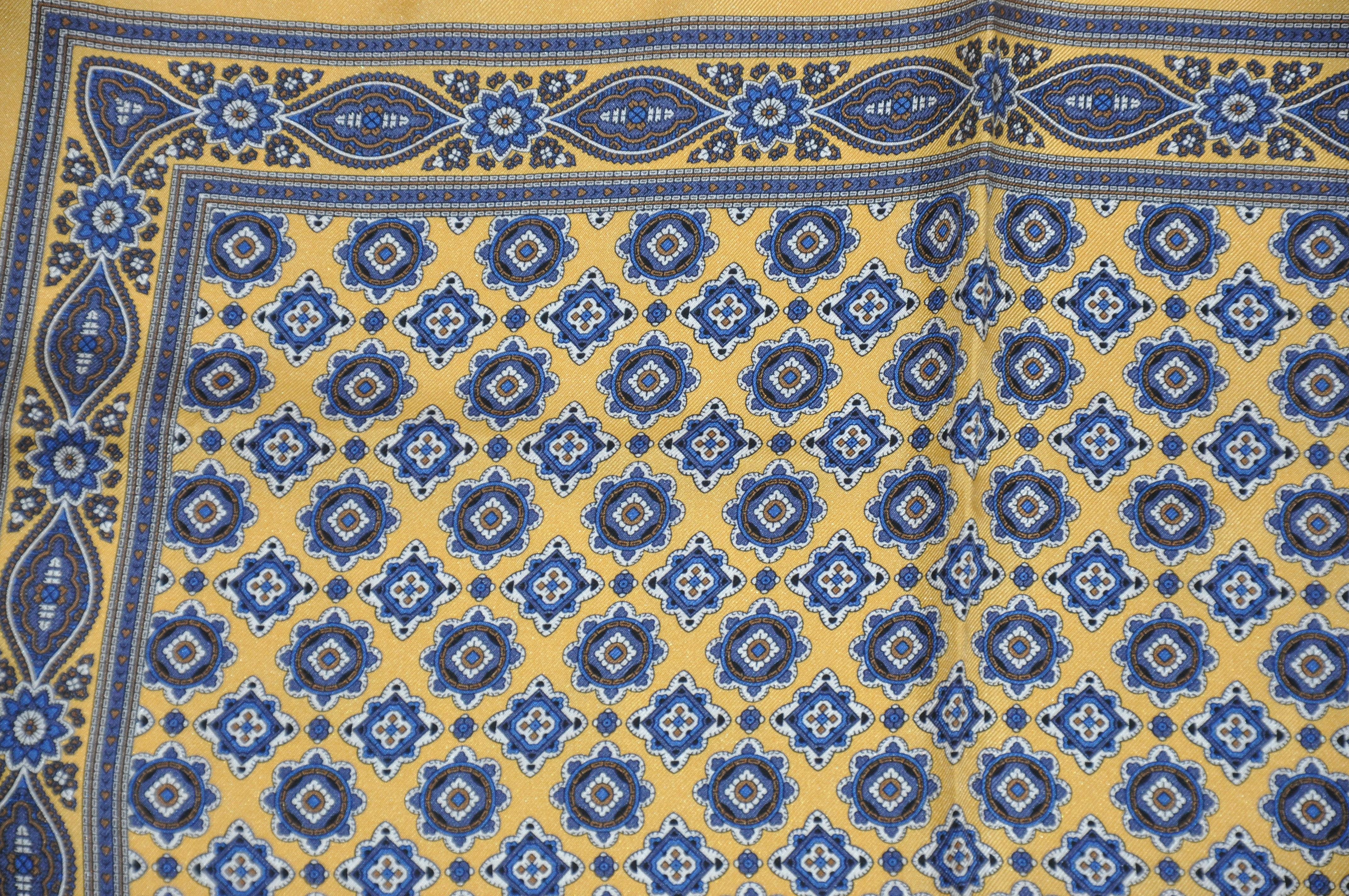      Diese wunderbar elegante Herren Seidentaschentuch mit goldenen Grenzen rund um majestätische Multi-blaue Mitte Seide Taschentuch mit handgerollten Kanten akzentuiert, misst 17 Zoll von 17 Zoll. Hergestellt in Italien.