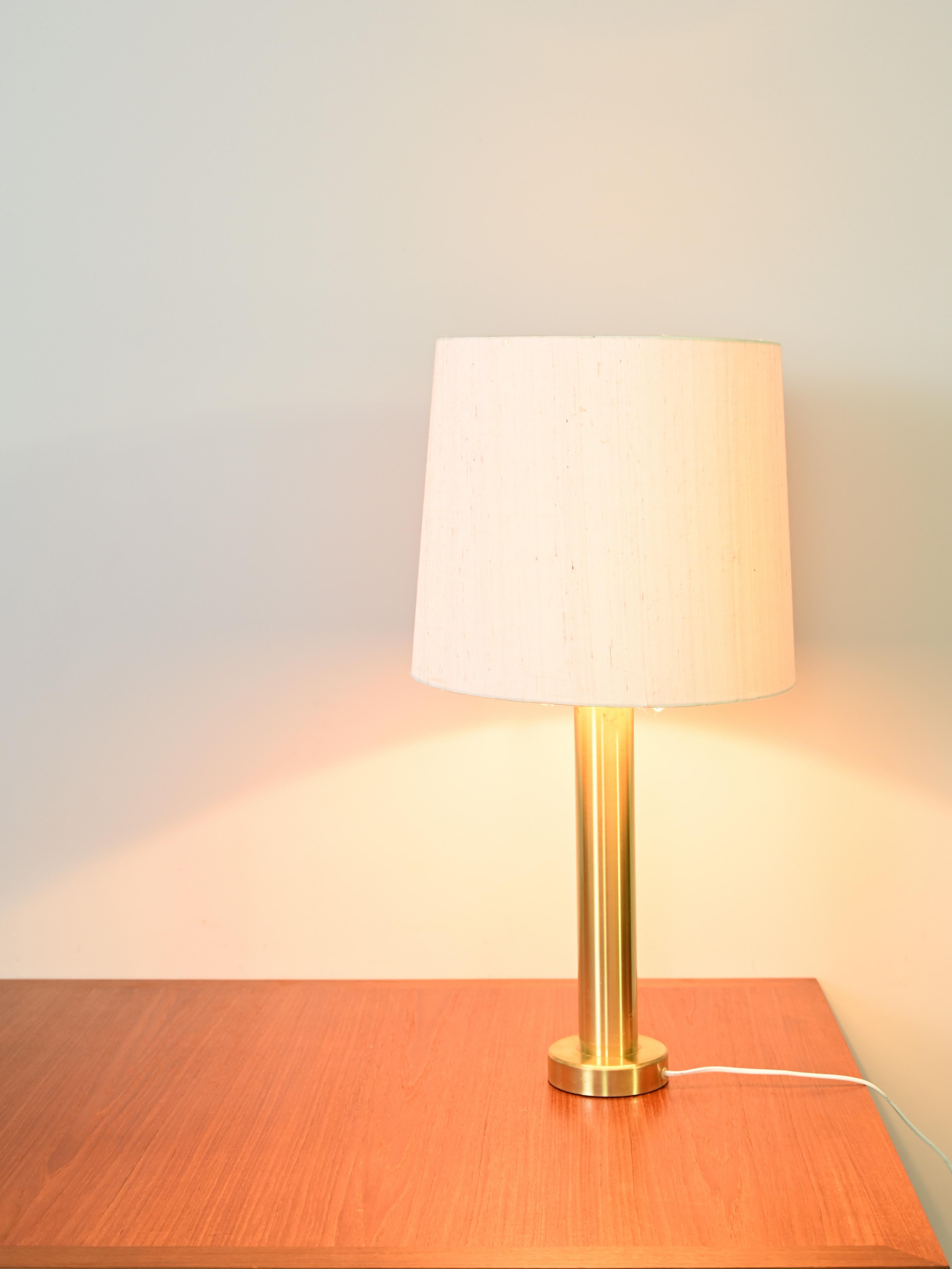 Elegant original vintage Scandinavian lamp from the 1960s.
 
A design piece of timeless beautElegant original vintage Scandinavian lamp from the 1960s.
 
A design piece of timeless beauty. 
Consists of the gilded metal base and fabric shade