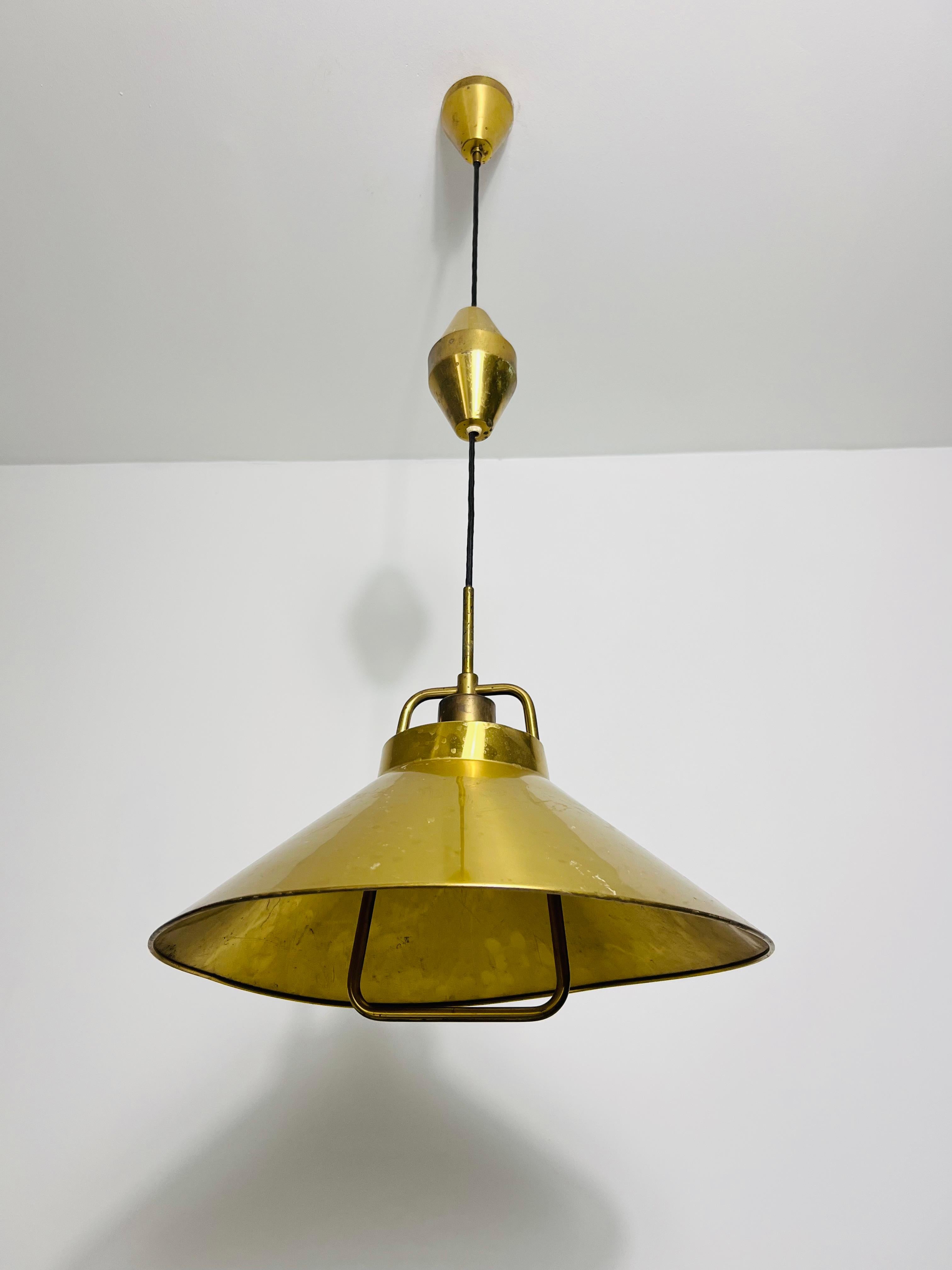 Questa lampada a sospensione con contrappeso in ottone di Fritz Schlägel per Lyfa Denmark è uno splendido esempio di design moderno di metà secolo. La sua estetica minimalista e le sue linee pulite riflettono l'eleganza senza tempo di questo