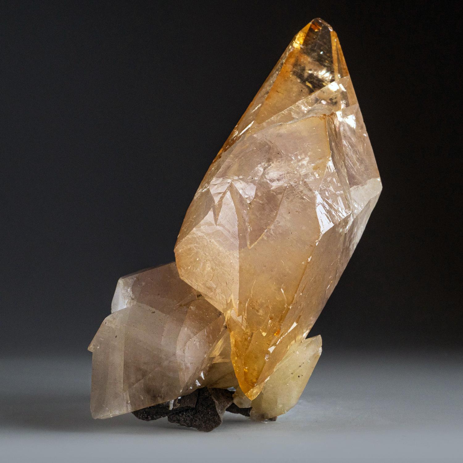 Grande calcite de qualité musée, transparente et lustrée, de couleur or foncé, avec un petit cristal de sphalérite à la base du cristal. Scalénoédrique à double terminaison, jumelé sur l'axe C, avec des faces rentrantes bien définies et des faces