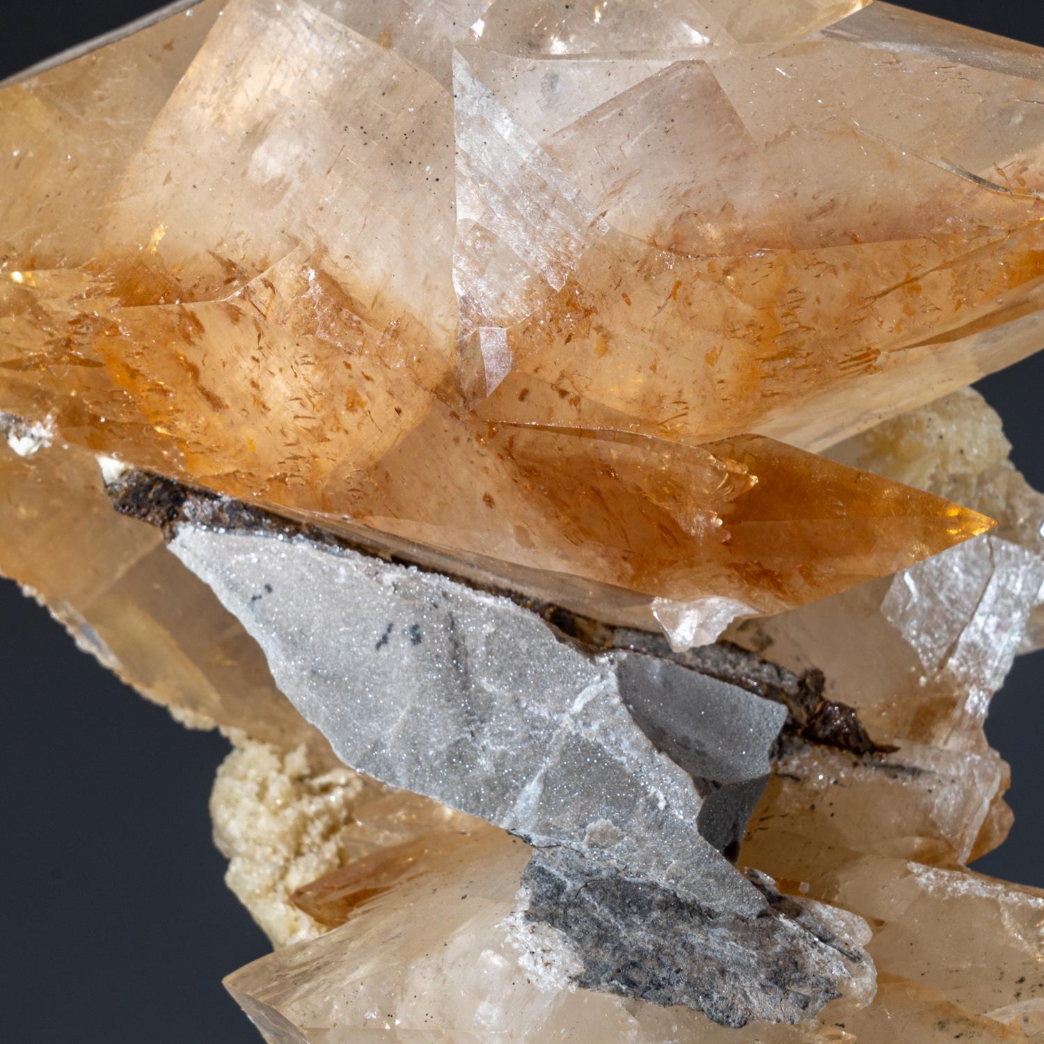 Large, museum-quality, lustrous transparent deep golden calcite with small sphalerite crystal at the base of the crystal. Double terminated scalenohedral twinned on the C-axis with well defined re-entrant faces, and crystal faces exhibiting