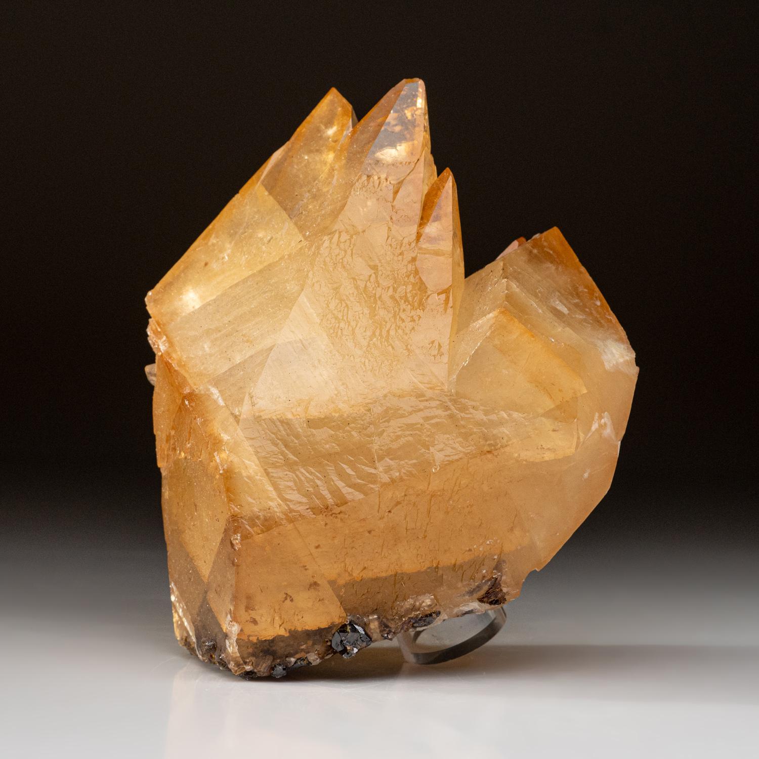 This specimen of golden calcite from Elmwood Mine, Carthage, Smith County, Tennessee is a stunning double-terminated scalenohedral twin with re-entrant faces and a small sphalerite crystal embedded in the back. Its lustrous, transparent look adds an