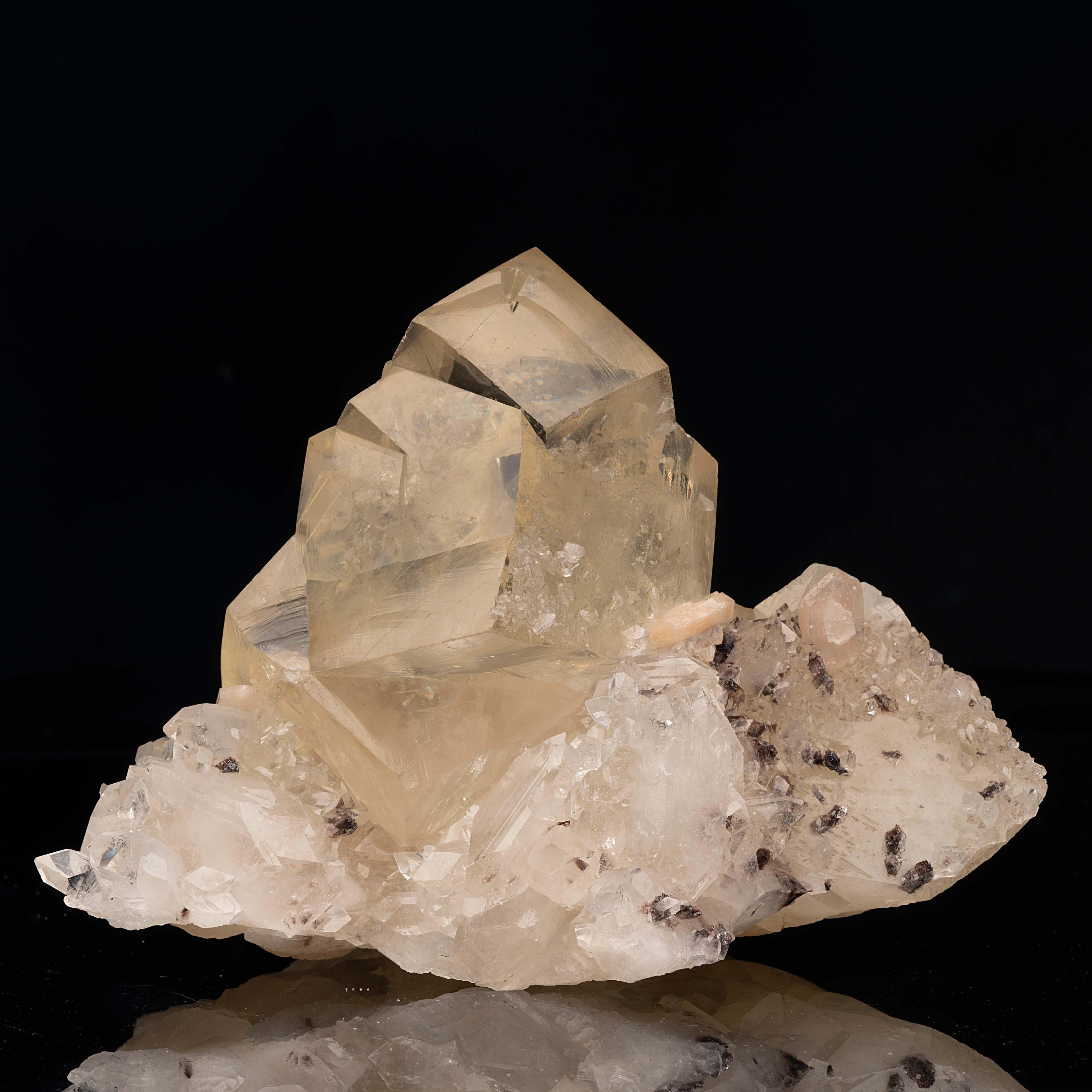 This true display specimen with fantastic aesthetics features two large cubic golden calcite crystals twinning into each other, with one appearing the engulf the other. The luster and especially the clarity of this calcite specimen is unparalleled.