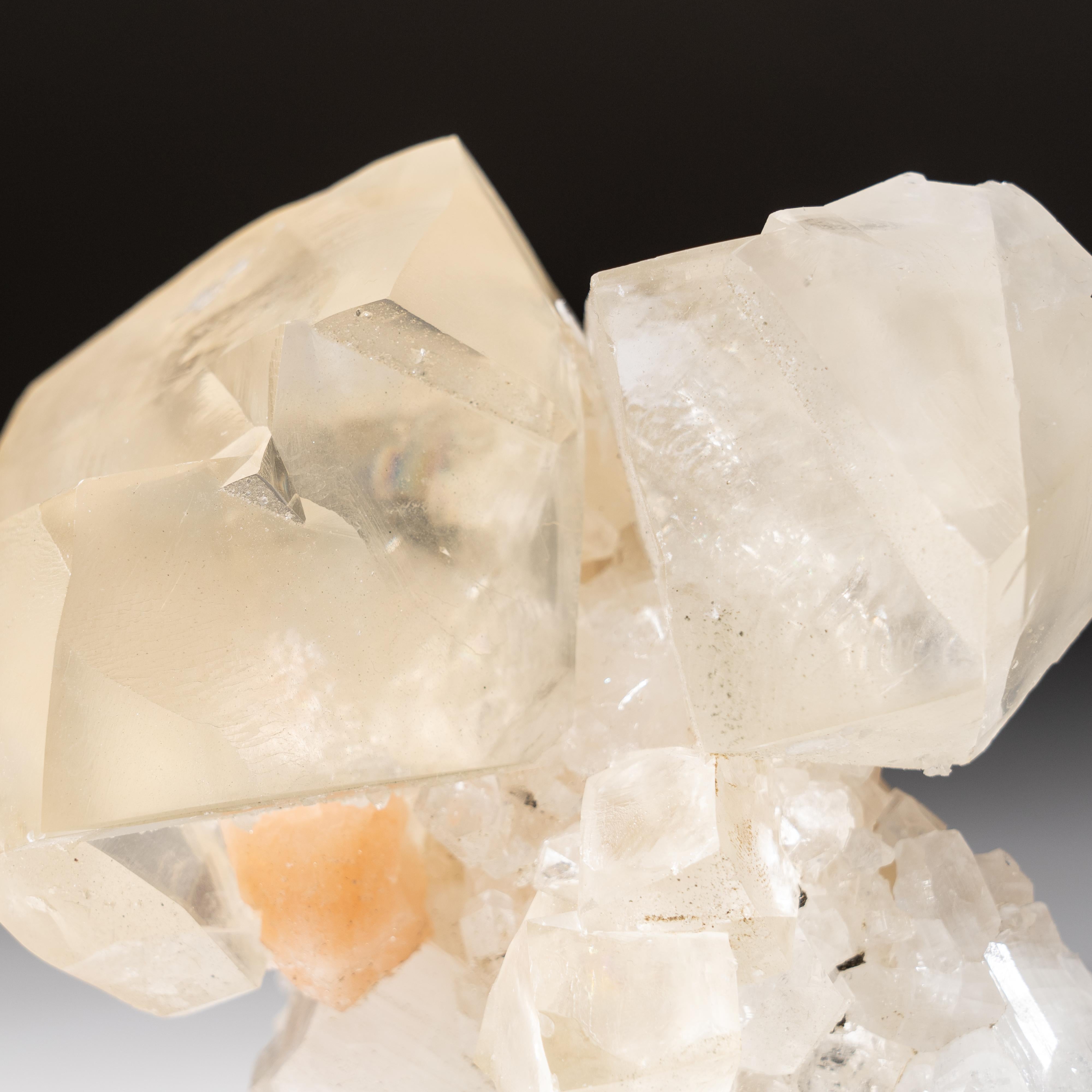 From Nasik District, Maharashtra, India

Large translucent double penetrating twinned crystals of calcite on translucent to transparent apophyllite crystal cluster matrix with pink stilbite in wheat sheave aggregates. The calcite has rich golden