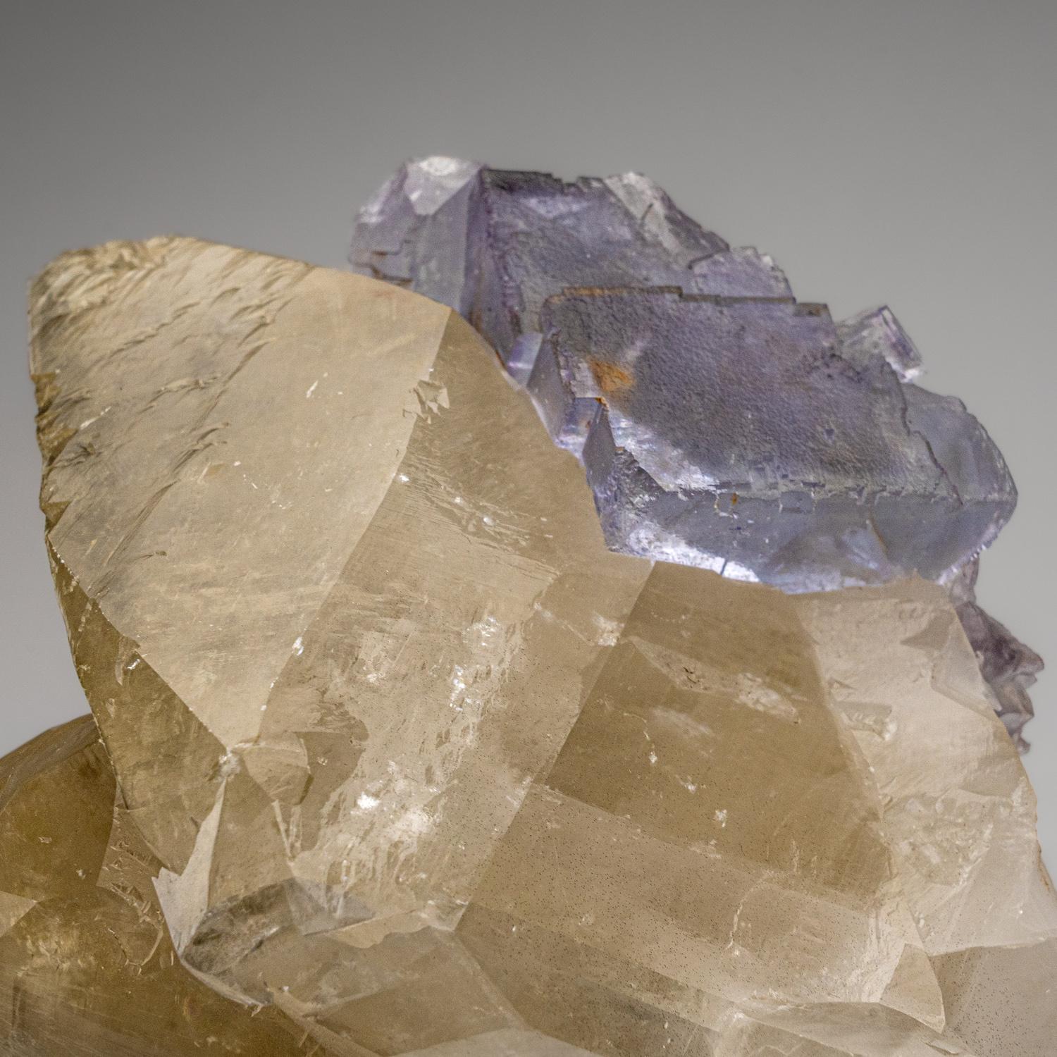 Xianghualing-Xianghuapu Mines, Hunan, China

Unusual, unique one of a kind specimen of calcite on purple green fluorite. Cubic fluorite crystals in an intersecting, stacked formation. Partial crystal of deep purple fluorite with complex surfaces