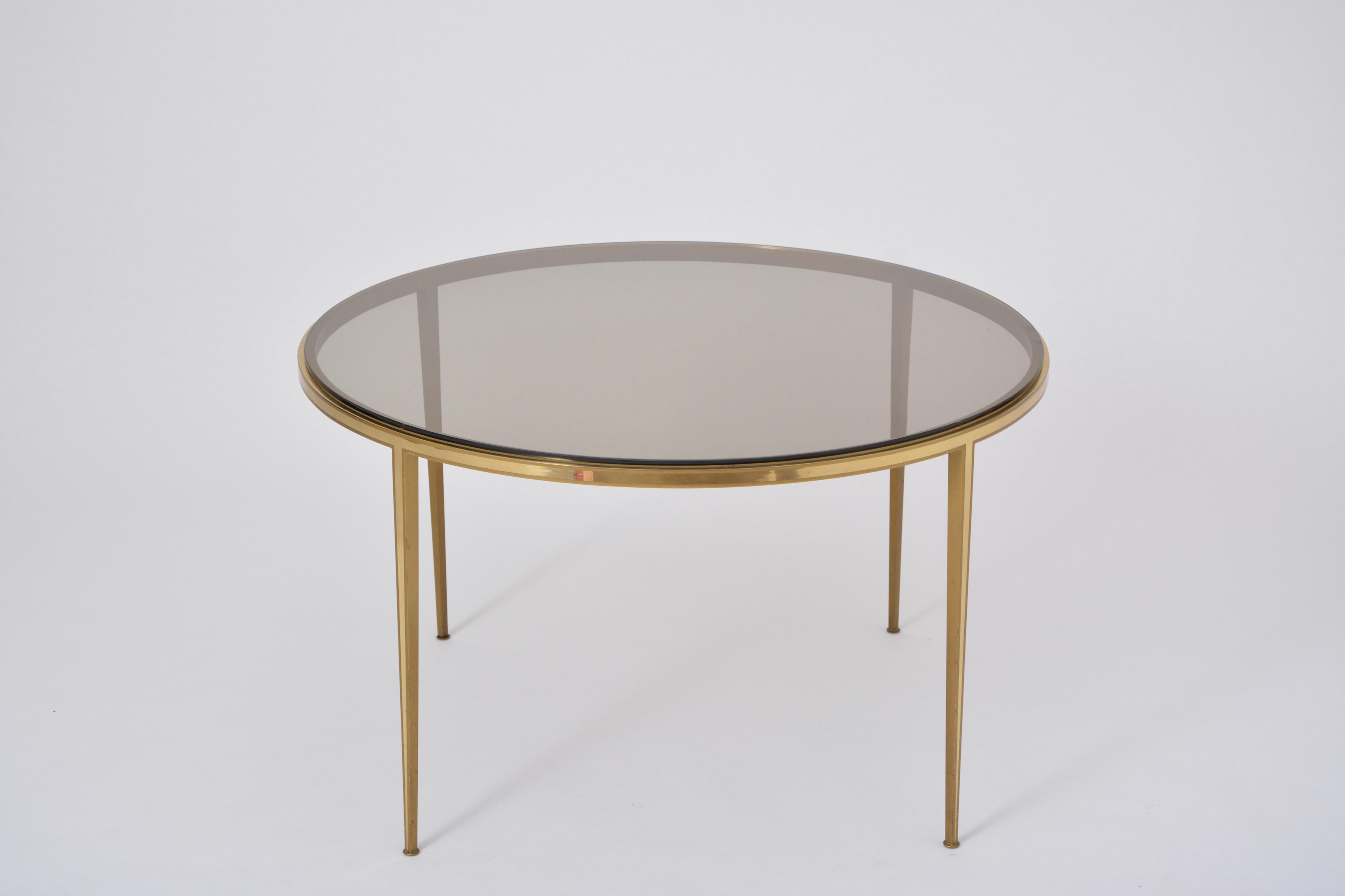 Golden circular Mid-Century Modern Brass coffee table by Vereinigte Werkstätten

Circular coffee table produced by Vereinigte Werkstätten München in the 1960s. The top is made of smoked glass. Normal signs of wear, light scratches to the glass top.