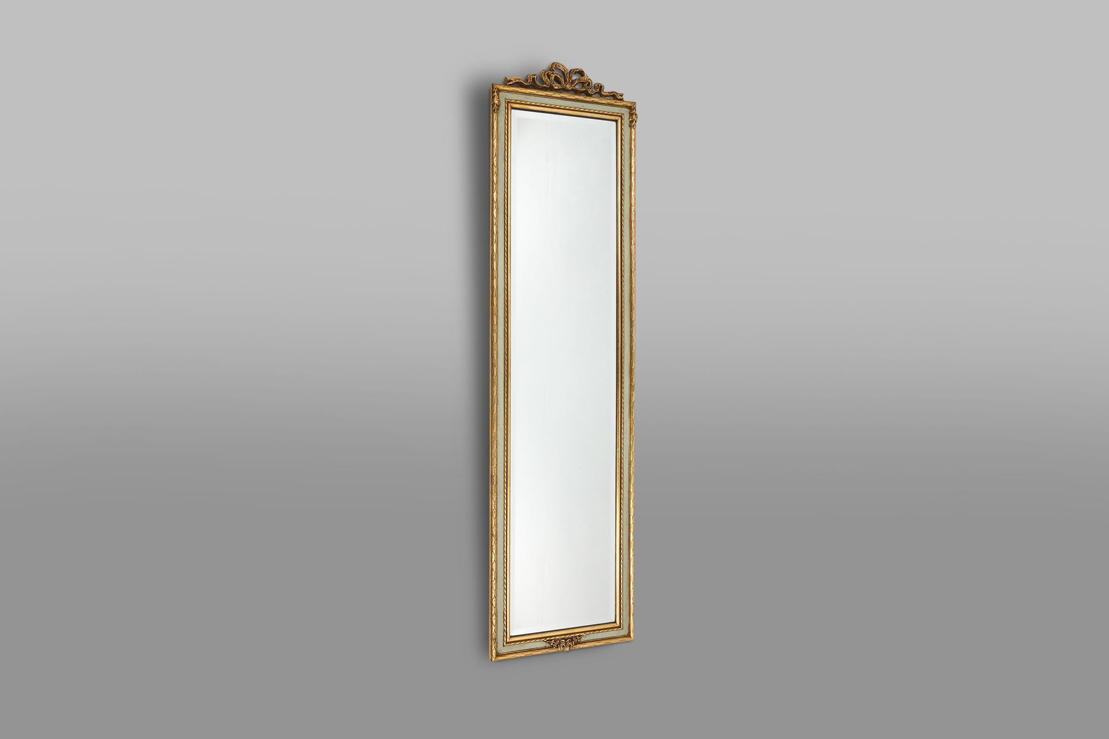 Small golden classic wall mirror with some nice classical details as a bow on top.