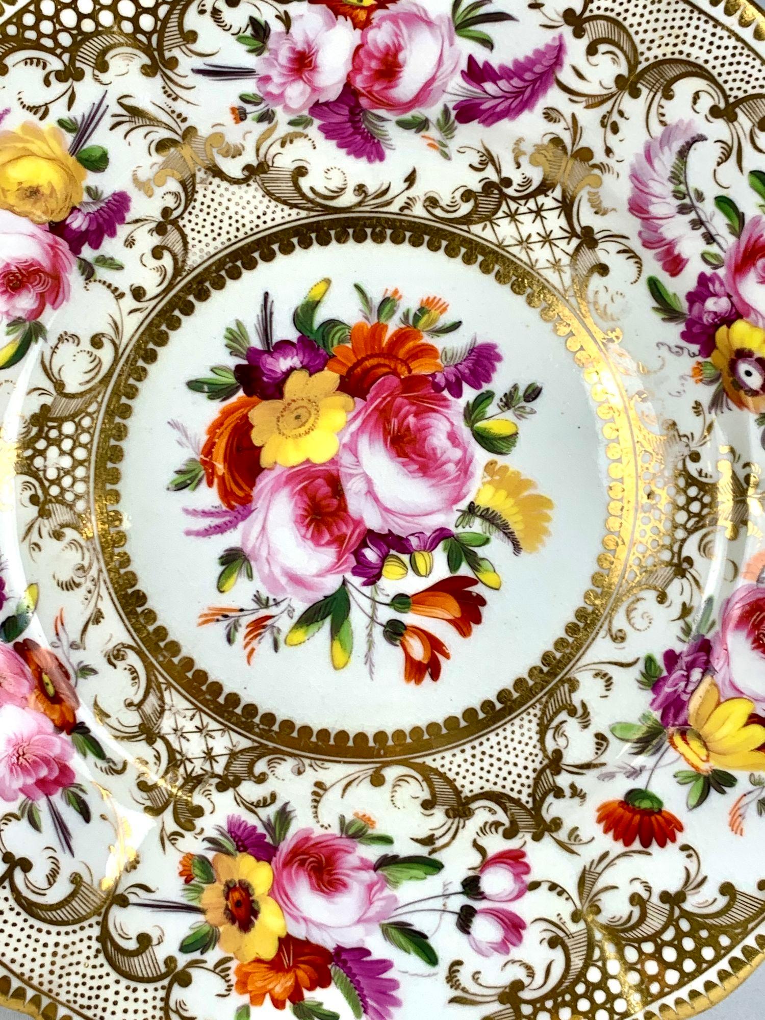 Questo piatto di Coalport è stato dipinto e dorato a mano in Inghilterra nel 1825 circa.
Mostra bouquet di rose rosa e altri bellissimi fiori nei toni dell'arancio, del giallo e del viola, tutti affiancati da foglie verdi.
Al centro è raffigurato un